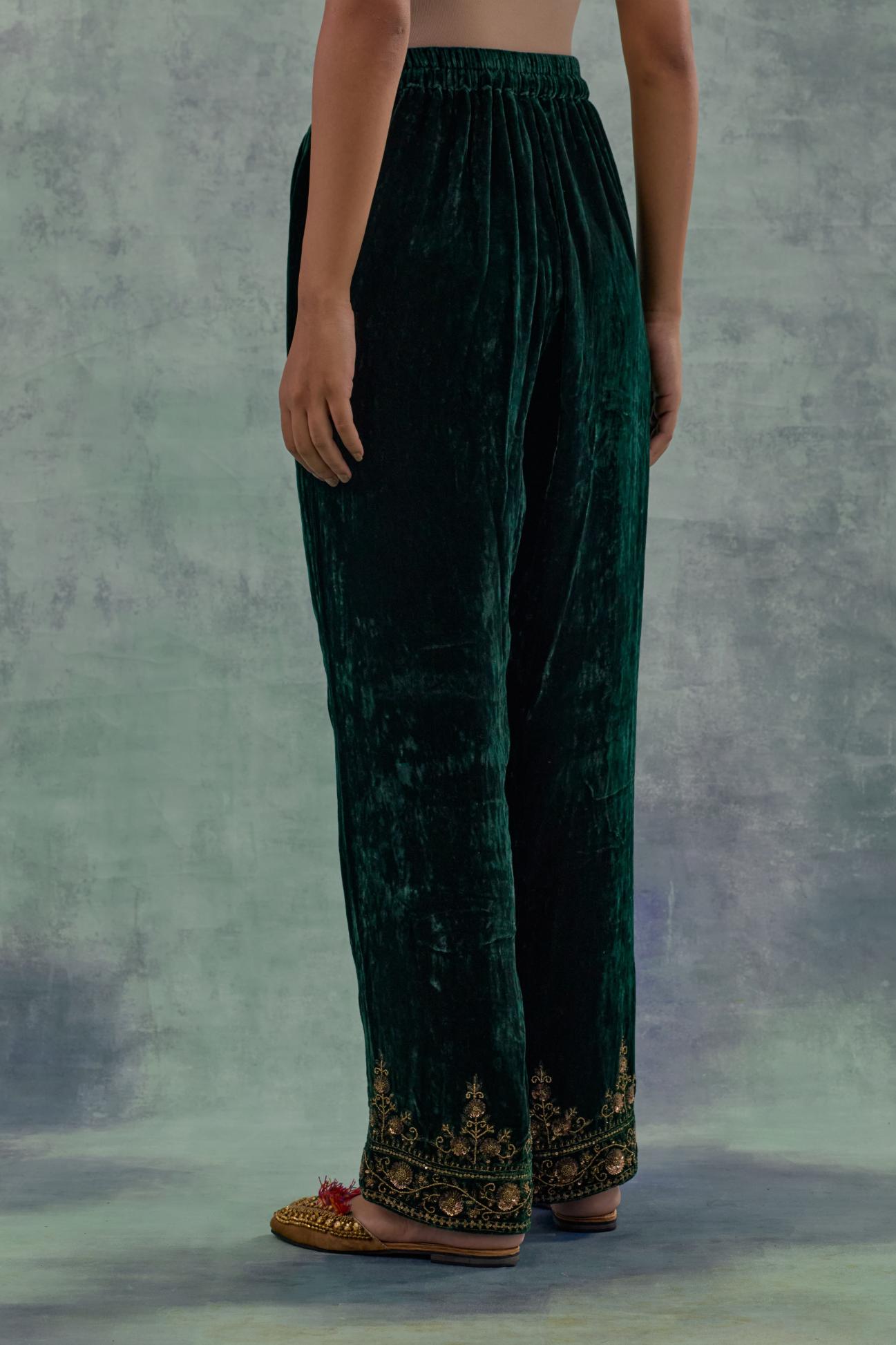 Emerald Green velvet straight pants. The hem is highlighted with hand-embroidered bead, sequins and zari motifs.