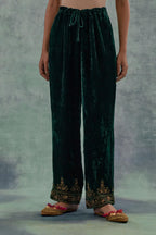 Emerald Green velvet straight pants. The hem is highlighted with hand-embroidered bead, sequins and zari motifs.