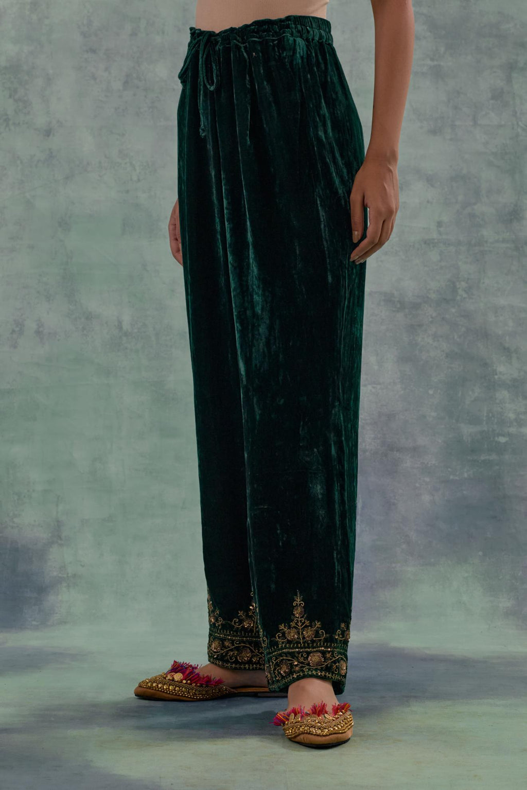 Emerald Green velvet straight pants. The hem is highlighted with hand-embroidered bead, sequins and zari motifs.