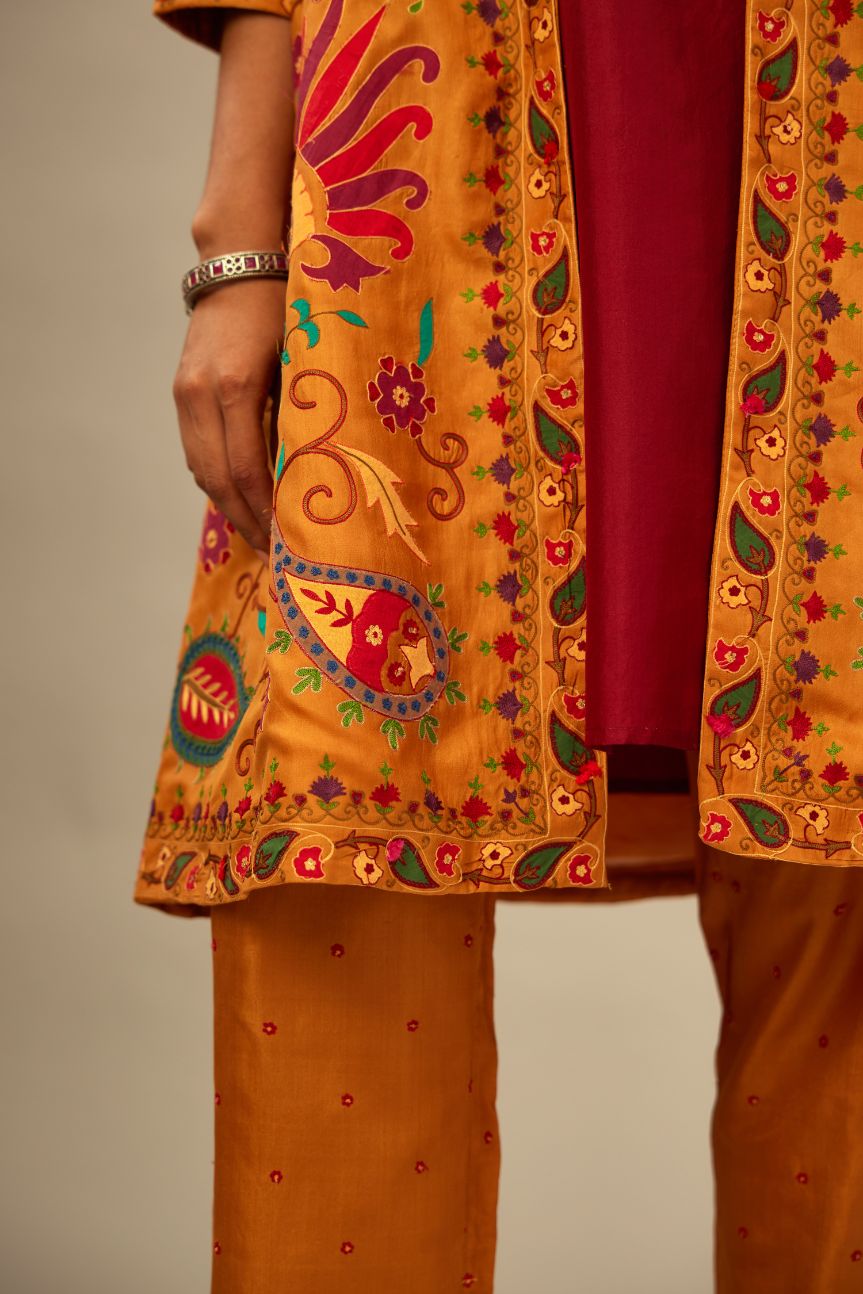 Mustard short front open A-line single button light jacket set, fully embroidered with bold appliqué flowers, multi-colored aari threadwork and silk tassels.