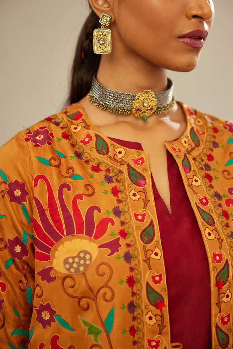 Mustard short front open A-line single button light jacket set, fully embroidered with bold appliqué flowers, multi-colored aari threadwork and silk tassels.