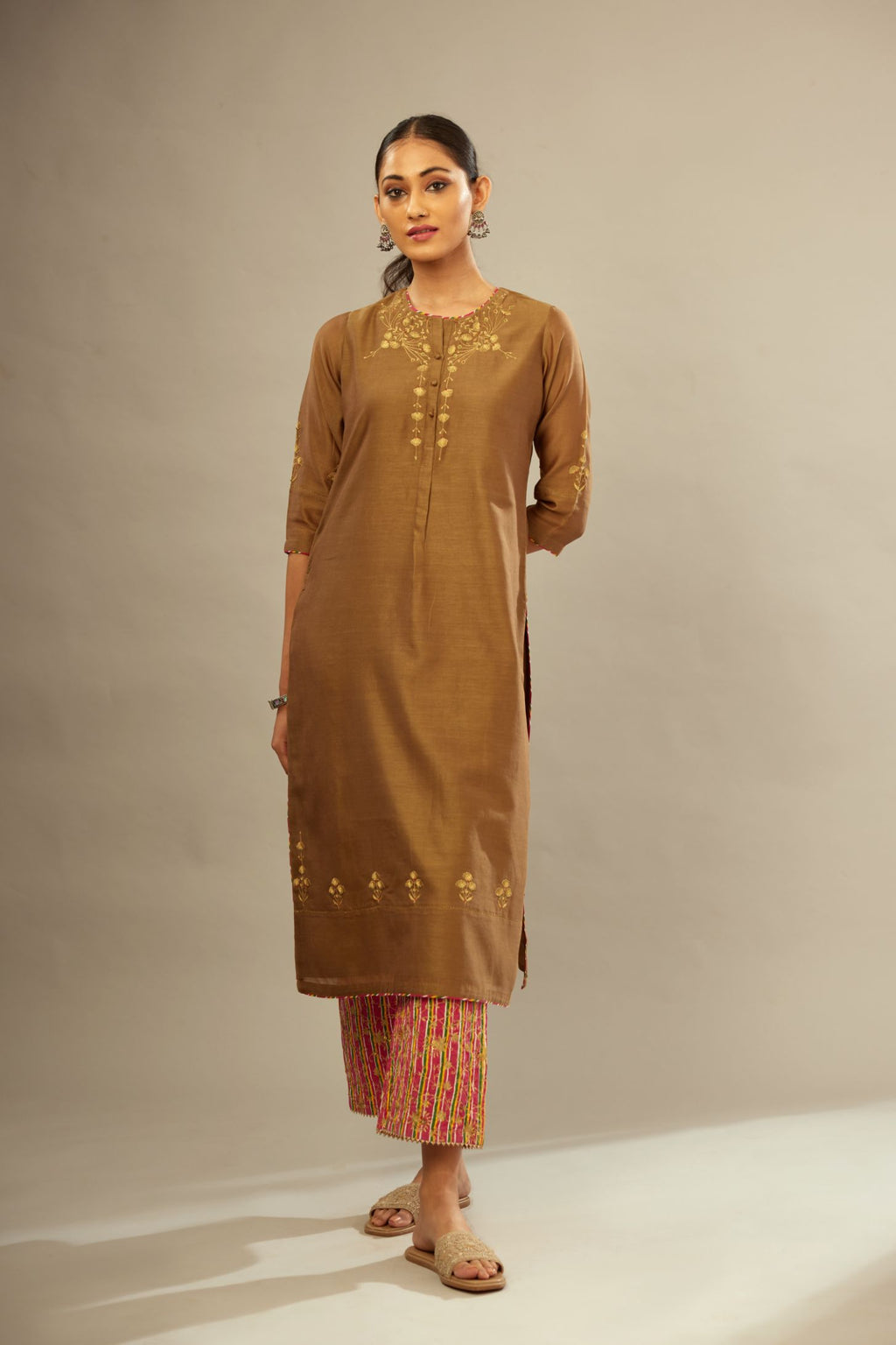 Olive straight kurta set with silver zari and contrasting thread embroidery, hem and sleeves highlighted with zari faggoting.