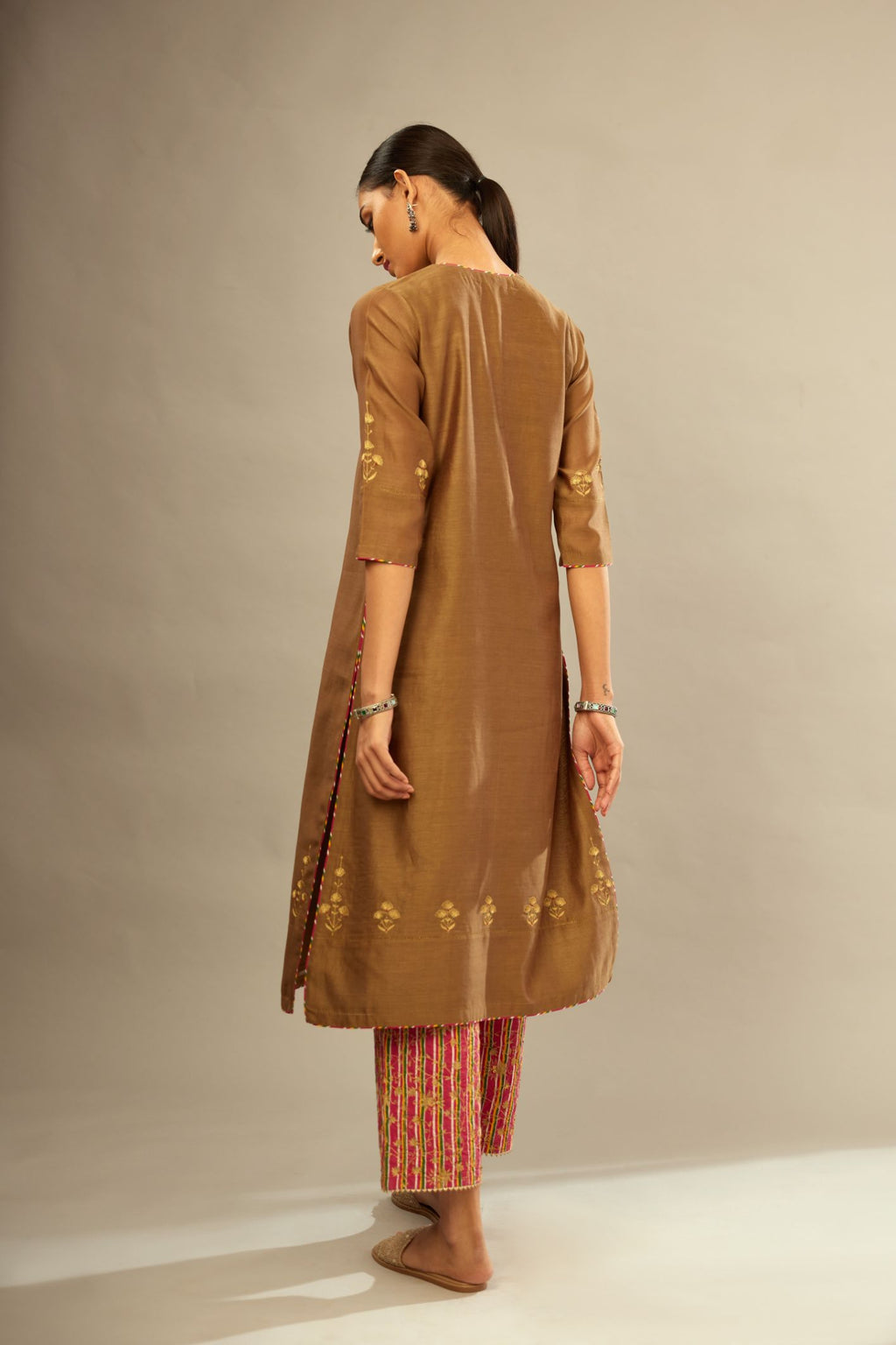 Olive straight kurta set with silver zari and contrasting thread embroidery, hem and sleeves highlighted with zari faggoting.