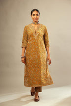 Mustard yellow silk velvet straight kurta set with delicate thread embroidery jaal all-over offset with bold gold dori embroidery at neck, sleeves and hem.