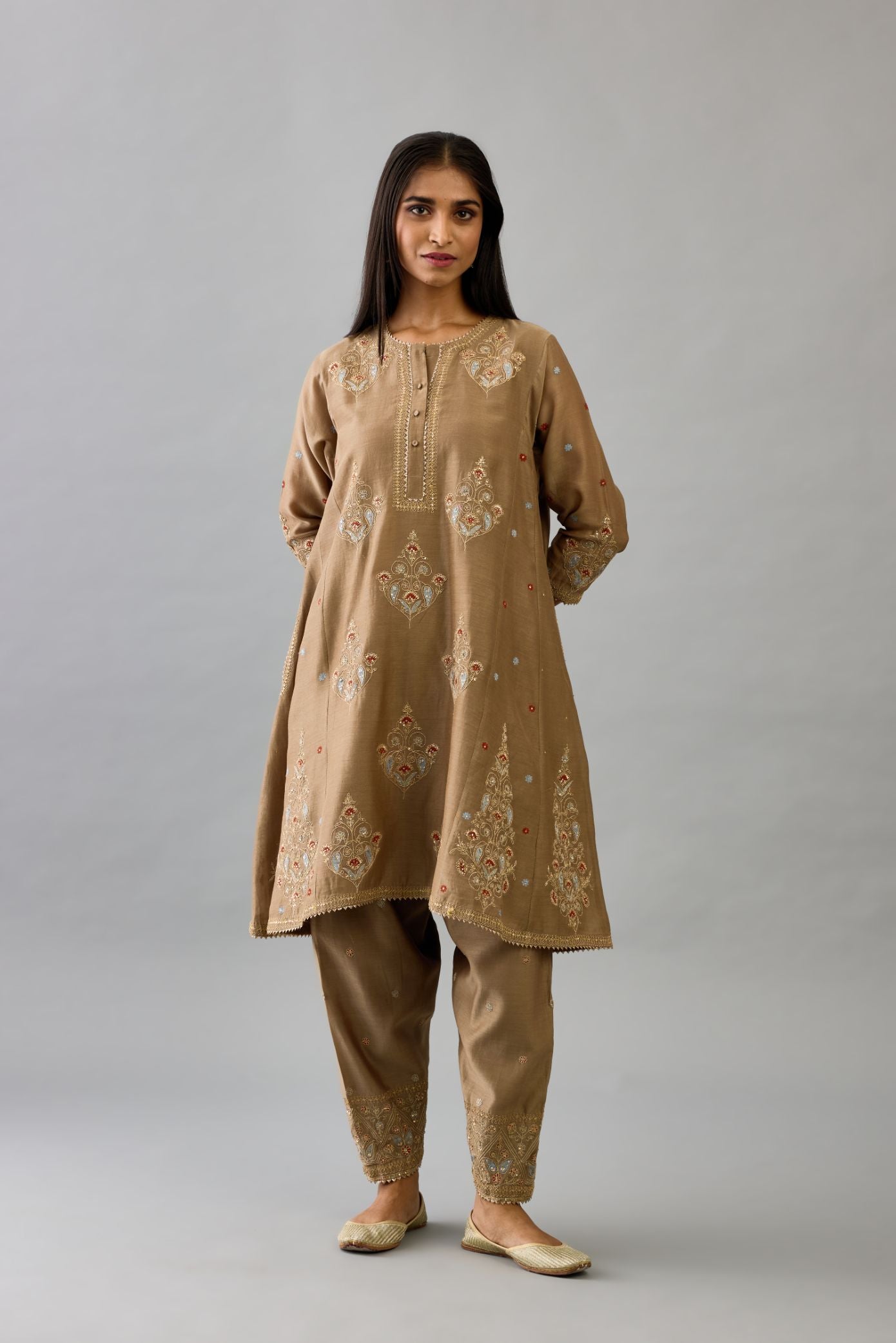 Taupe silk chanderi short kalidar phiran style kurta set with dori and contrast silk thread embroidery, highlighted with gold sequins work.