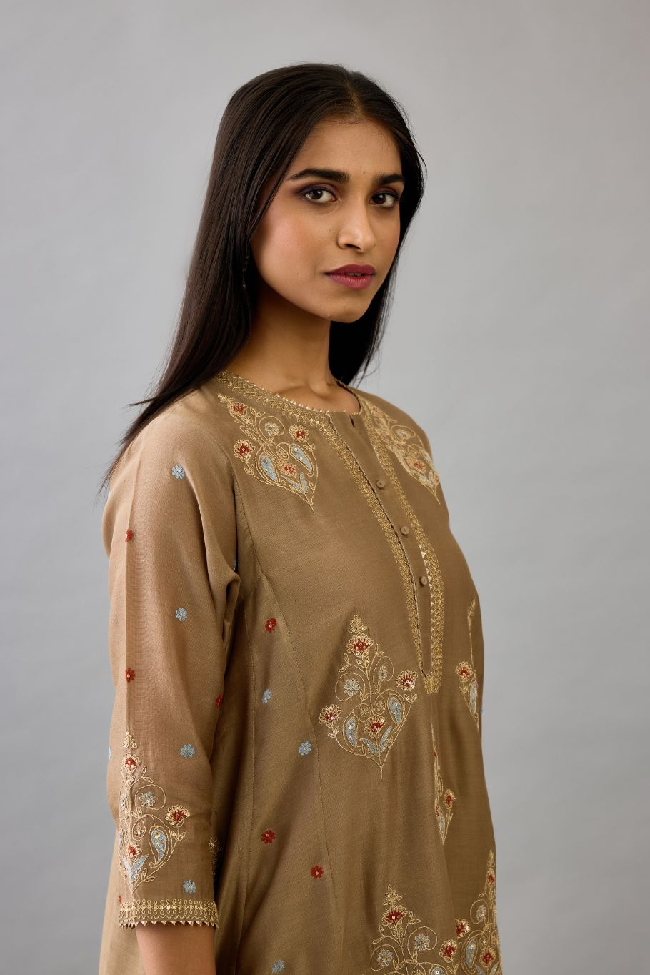 Taupe silk chanderi short kalidar phiran style kurta set with dori and contrast silk thread embroidery, highlighted with gold sequins work.