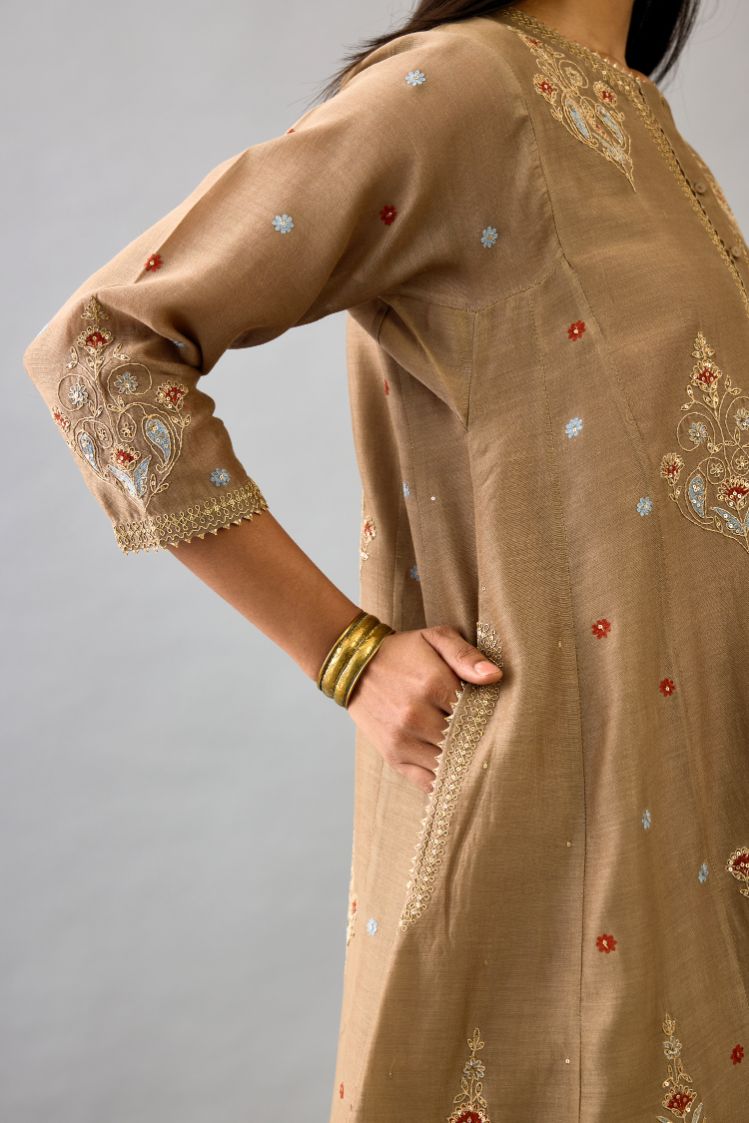 Taupe silk chanderi short kalidar phiran style kurta set with dori and contrast silk thread embroidery, highlighted with gold sequins work.