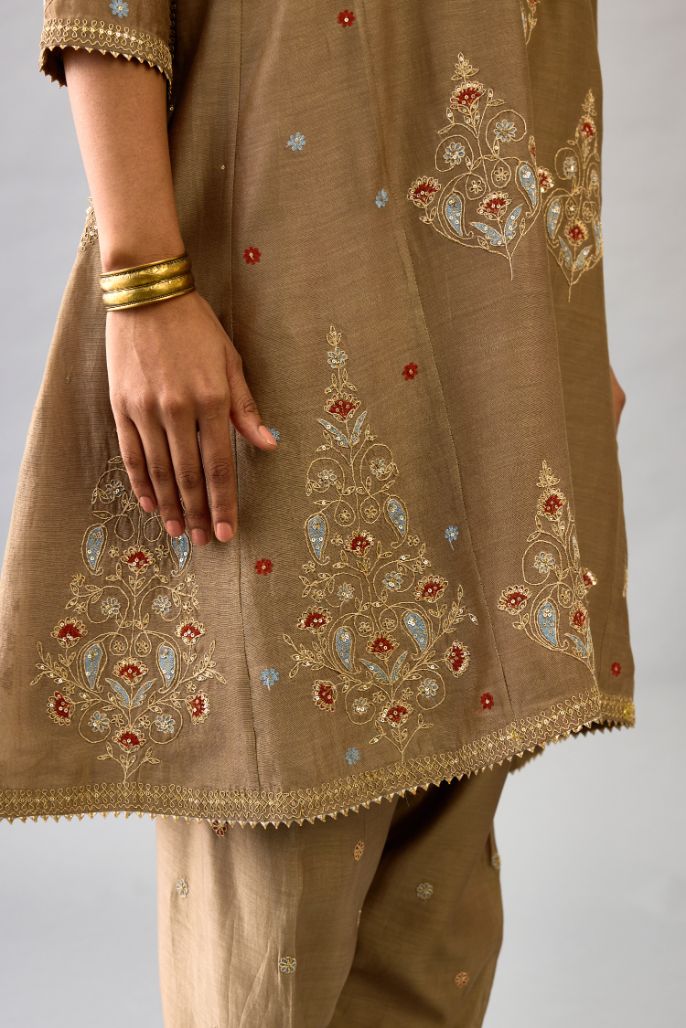 Taupe silk chanderi short kalidar phiran style kurta set with dori and contrast silk thread embroidery, highlighted with gold sequins work.
