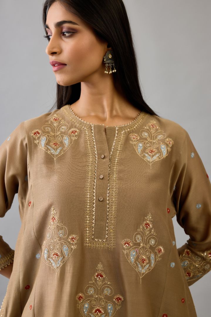 Taupe silk chanderi short kalidar phiran style kurta set with dori and contrast silk thread embroidery, highlighted with gold sequins work.