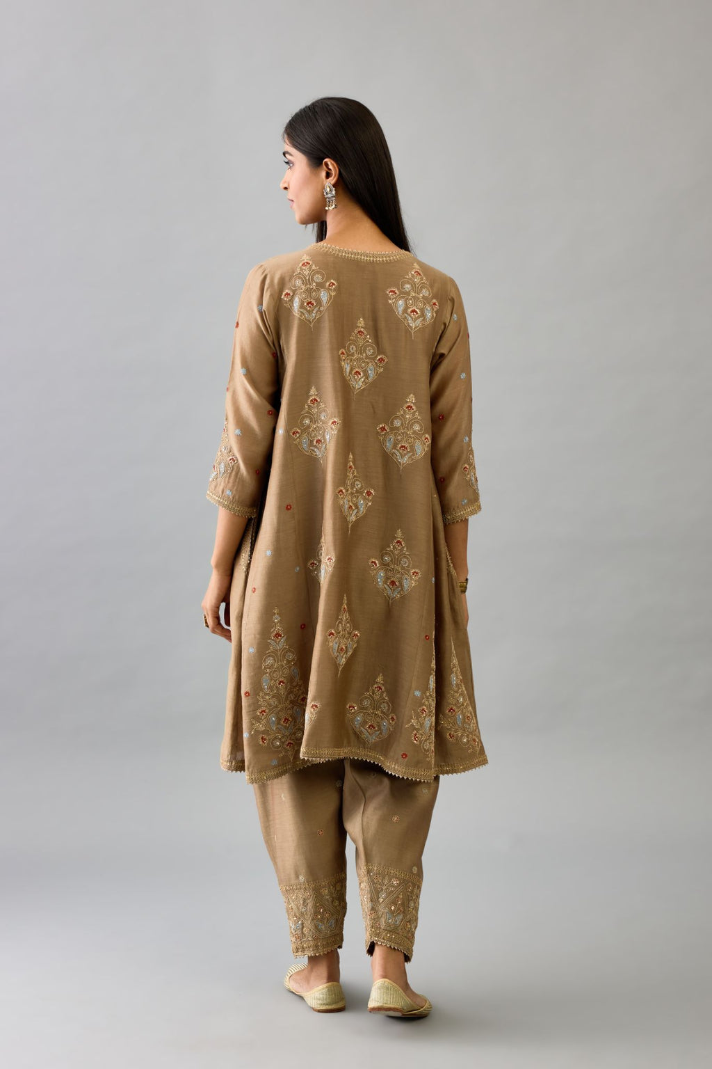 Taupe silk chanderi short kalidar phiran style kurta set with dori and contrast silk thread embroidery, highlighted with gold sequins work.
