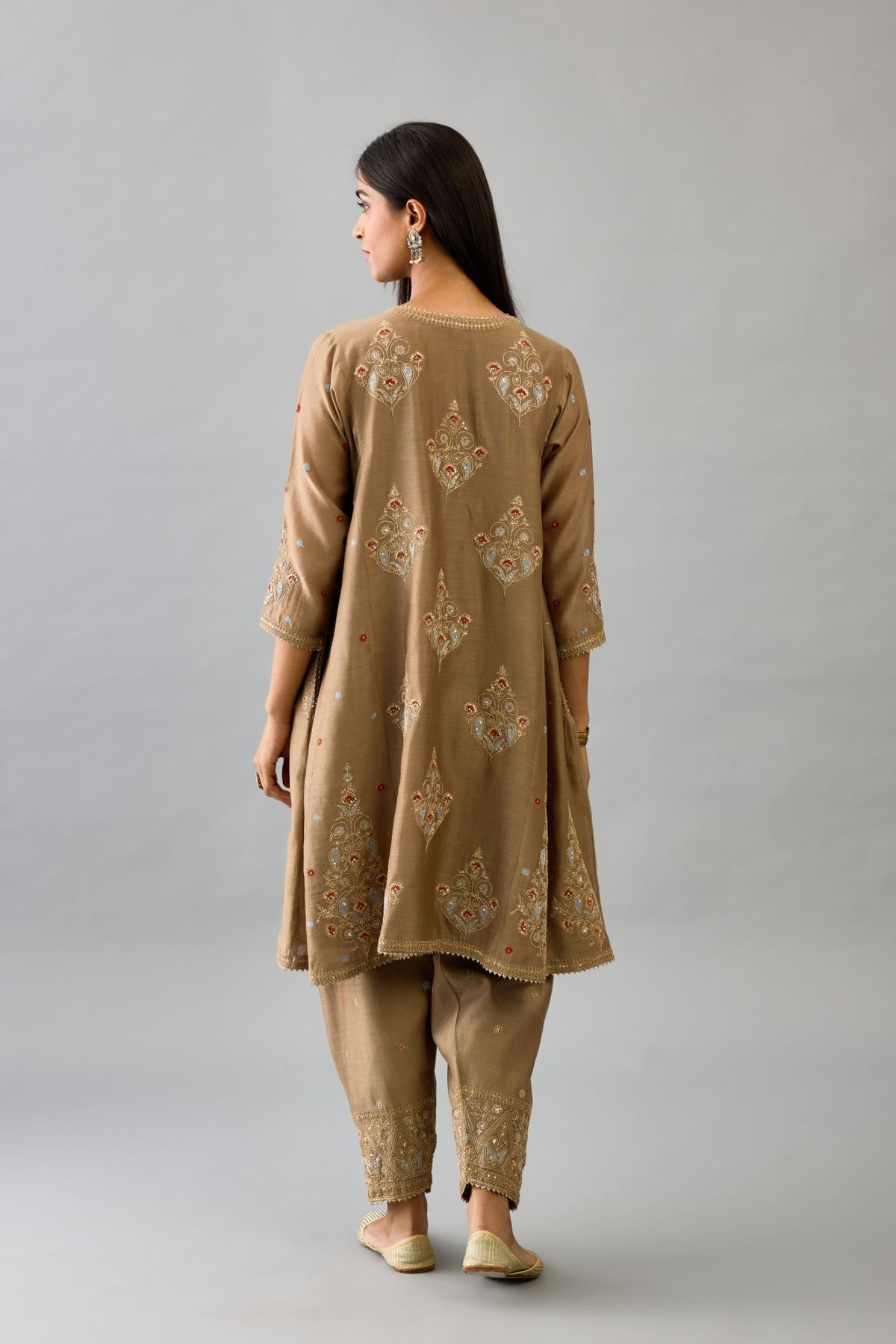 Taupe silk chanderi short kalidar phiran style kurta set with dori and contrast silk thread embroidery, highlighted with gold sequins work.