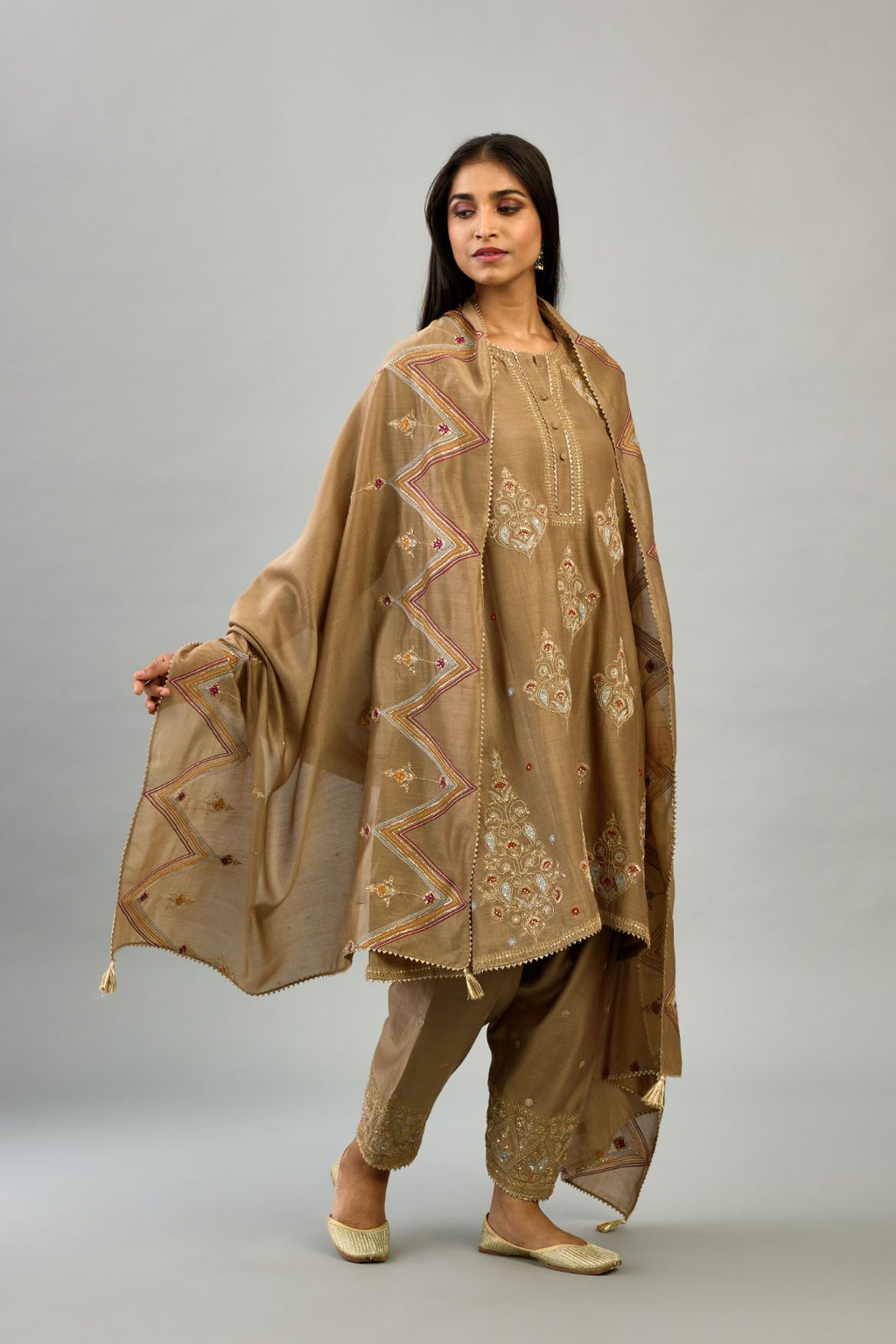 Taupe silk chanderi short kalidar phiran style kurta set with dori and contrast silk thread embroidery, highlighted with gold sequins work.