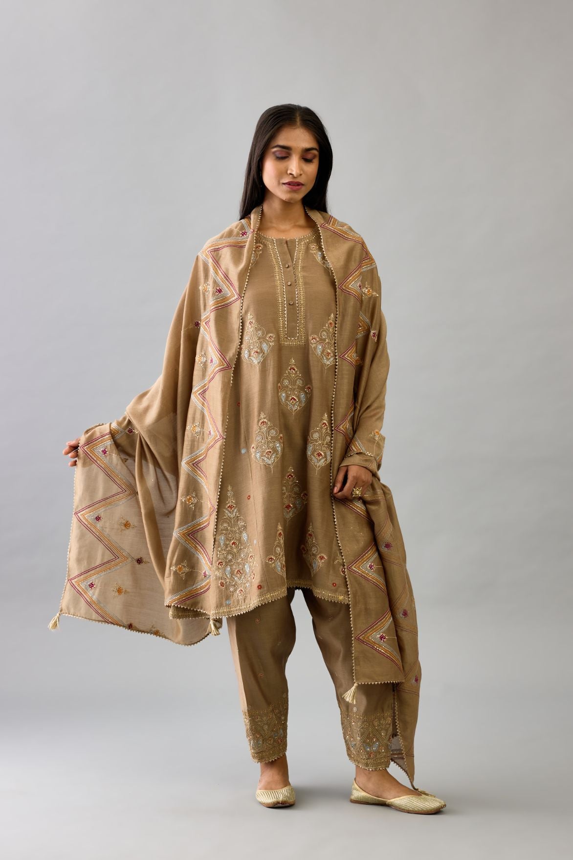 Taupe silk chanderi short kalidar phiran style kurta set with dori and contrast silk thread embroidery, highlighted with gold sequins work.