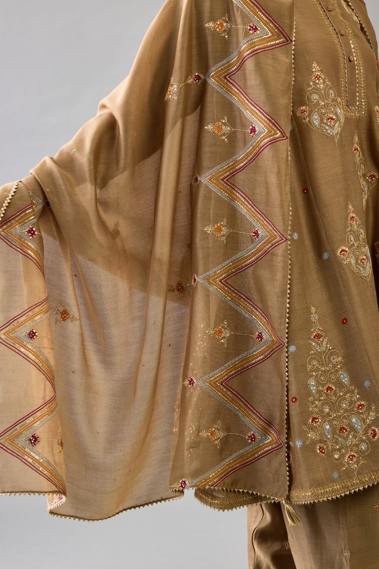 Taupe silk chanderi short kalidar phiran style kurta set with dori and contrast silk thread embroidery, highlighted with gold sequins work.