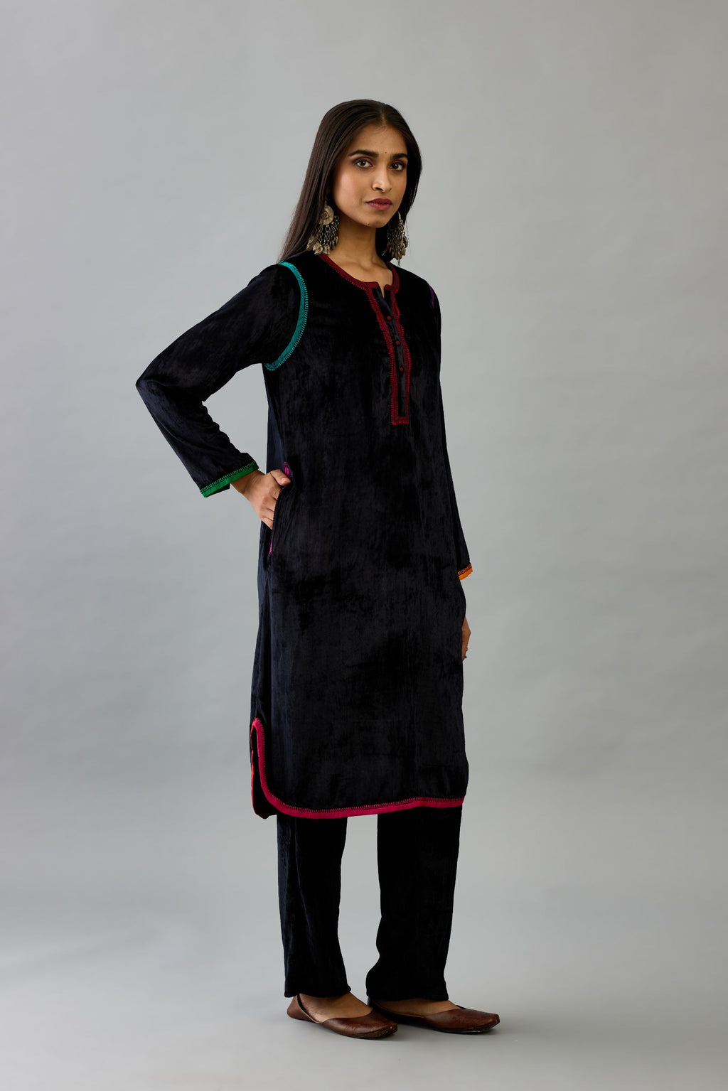 Black silk velvet short kurta set with round hem and multi colored silk facing, highlighted with embroidery.