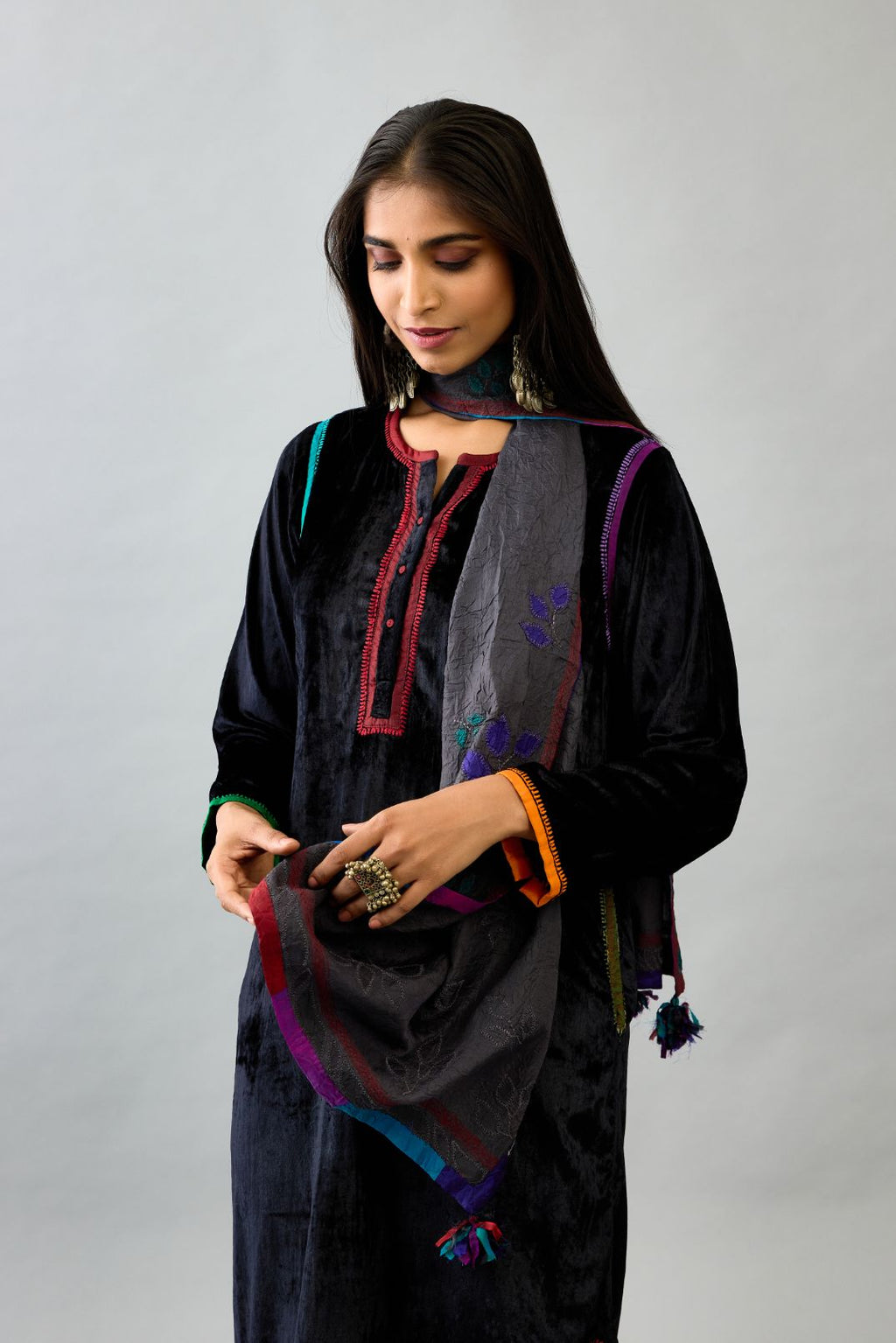 Black silk velvet short kurta set with round hem and multi colored silk facing, highlighted with embroidery.