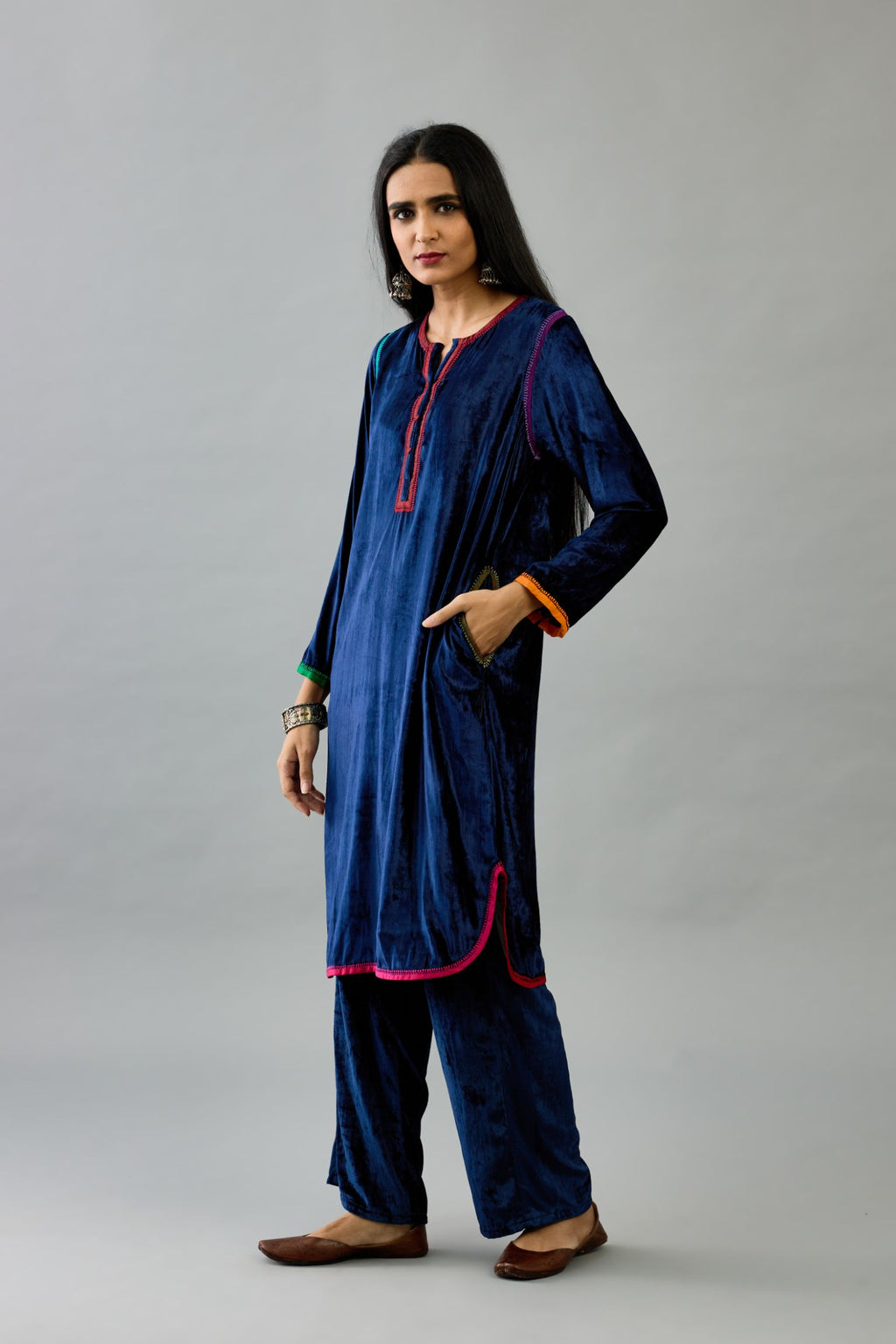 Blue silk velvet short kurta set with round hem and multi colored silk facing, highlighted with embroidery.