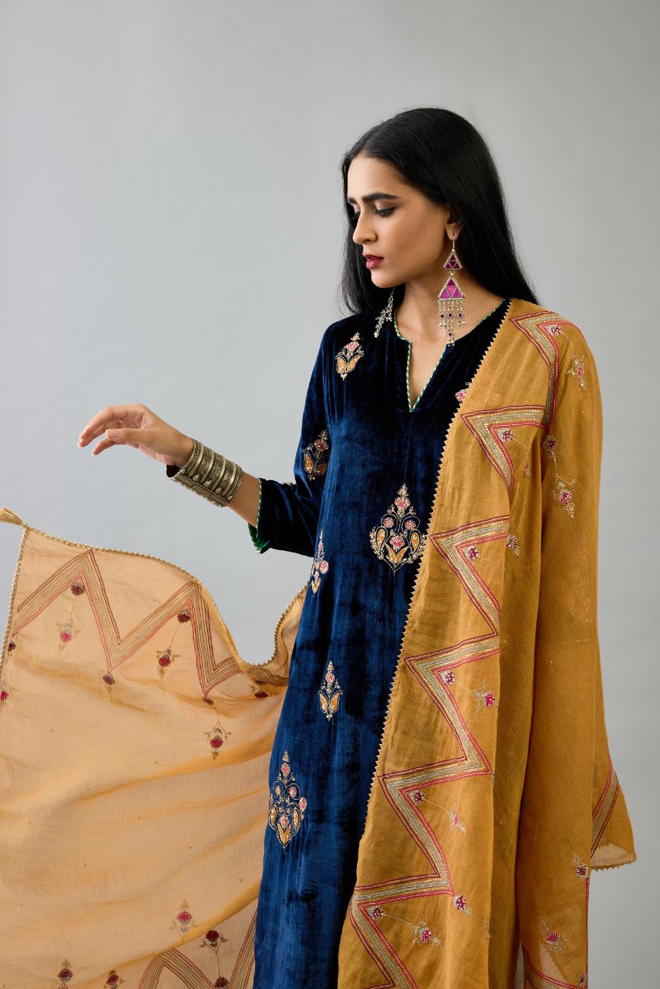 Blue silk velvet straight kurta set with zari, dori and contrast silk thread embroidered bootas, highlighted with gold sequins work.