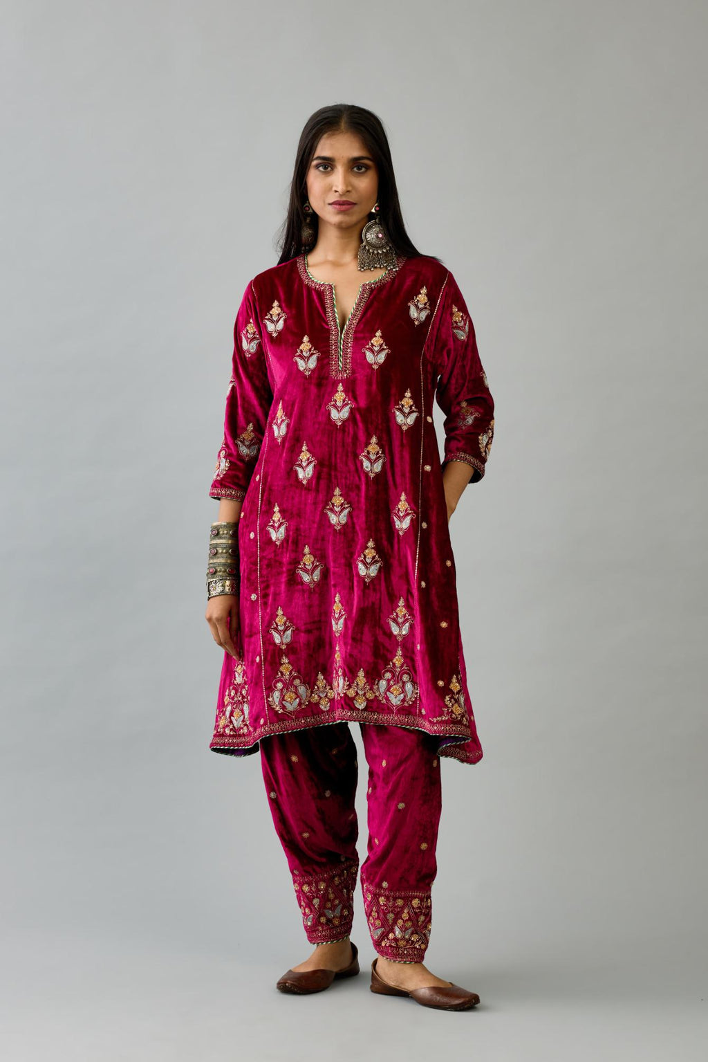 Fuchsia silk velvet A-line short kurta set with dori and contrast silk thread embroidery, highlighted with gold sequins work.