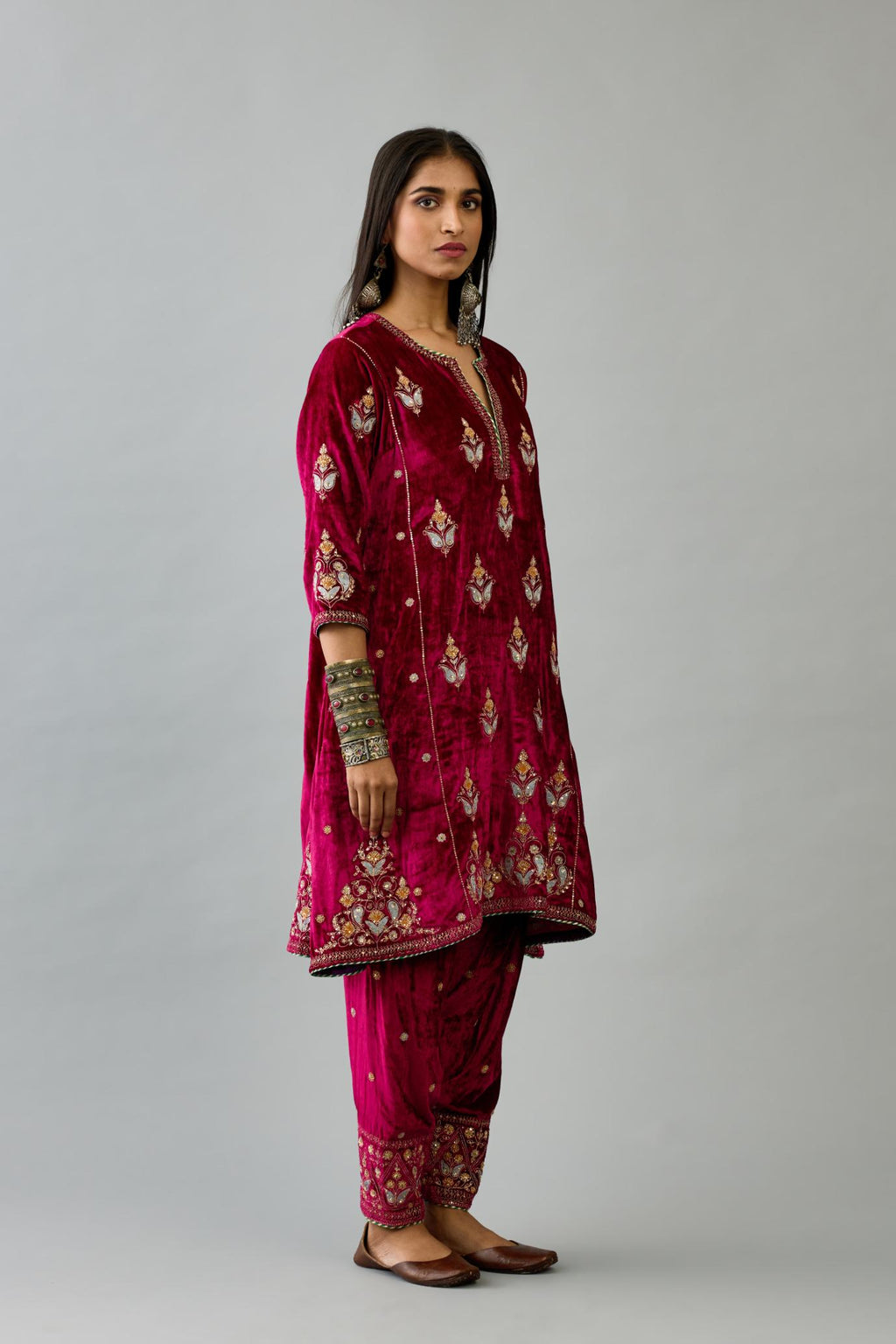 Fuchsia silk velvet A-line short kurta set with dori and contrast silk thread embroidery, highlighted with gold sequins work.