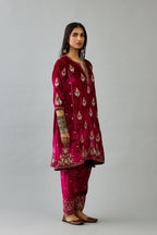 Fuchsia silk velvet A-line short kurta set with dori and contrast silk thread embroidery, highlighted with gold sequins work.