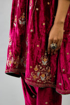 Fuchsia silk velvet A-line short kurta set with dori and contrast silk thread embroidery, highlighted with gold sequins work.