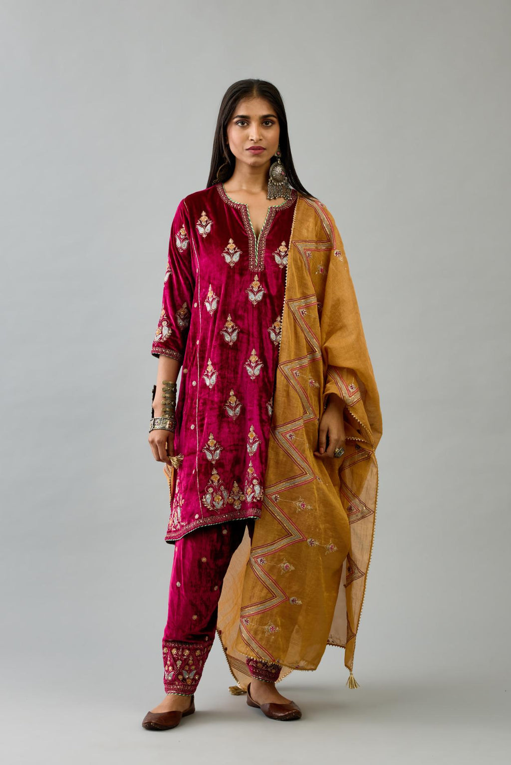 Fuchsia silk velvet A-line short kurta set with dori and contrast silk thread embroidery, highlighted with gold sequins work.