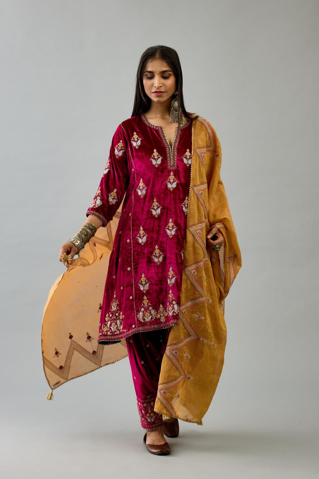 Fuchsia silk velvet A-line short kurta set with dori and contrast silk thread embroidery, highlighted with gold sequins work.