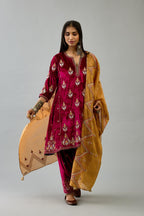 Fuchsia silk velvet A-line short kurta set with dori and contrast silk thread embroidery, highlighted with gold sequins work.