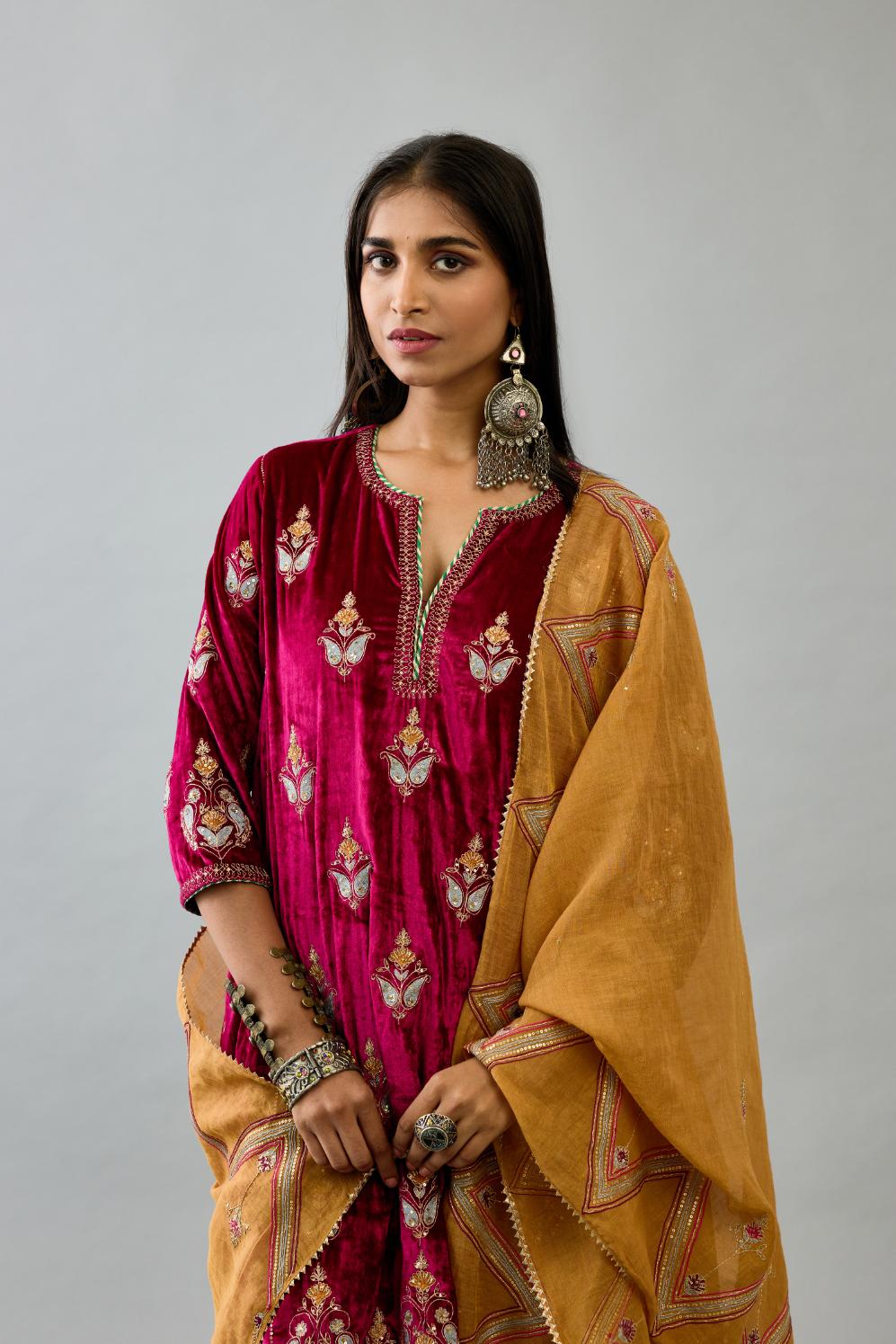 Fuchsia silk velvet A-line short kurta set with dori and contrast silk thread embroidery, highlighted with gold sequins work.