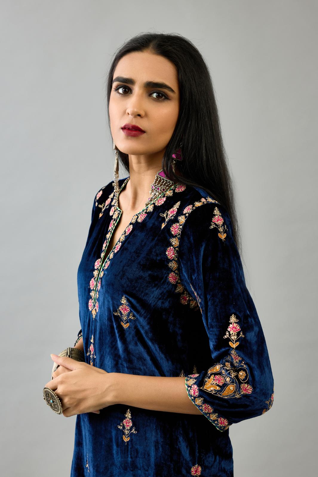 Blue silk velvet straight kurta set with all-over zari, dori and contrast silk thread embroidery, highlighted with gold sequins work.