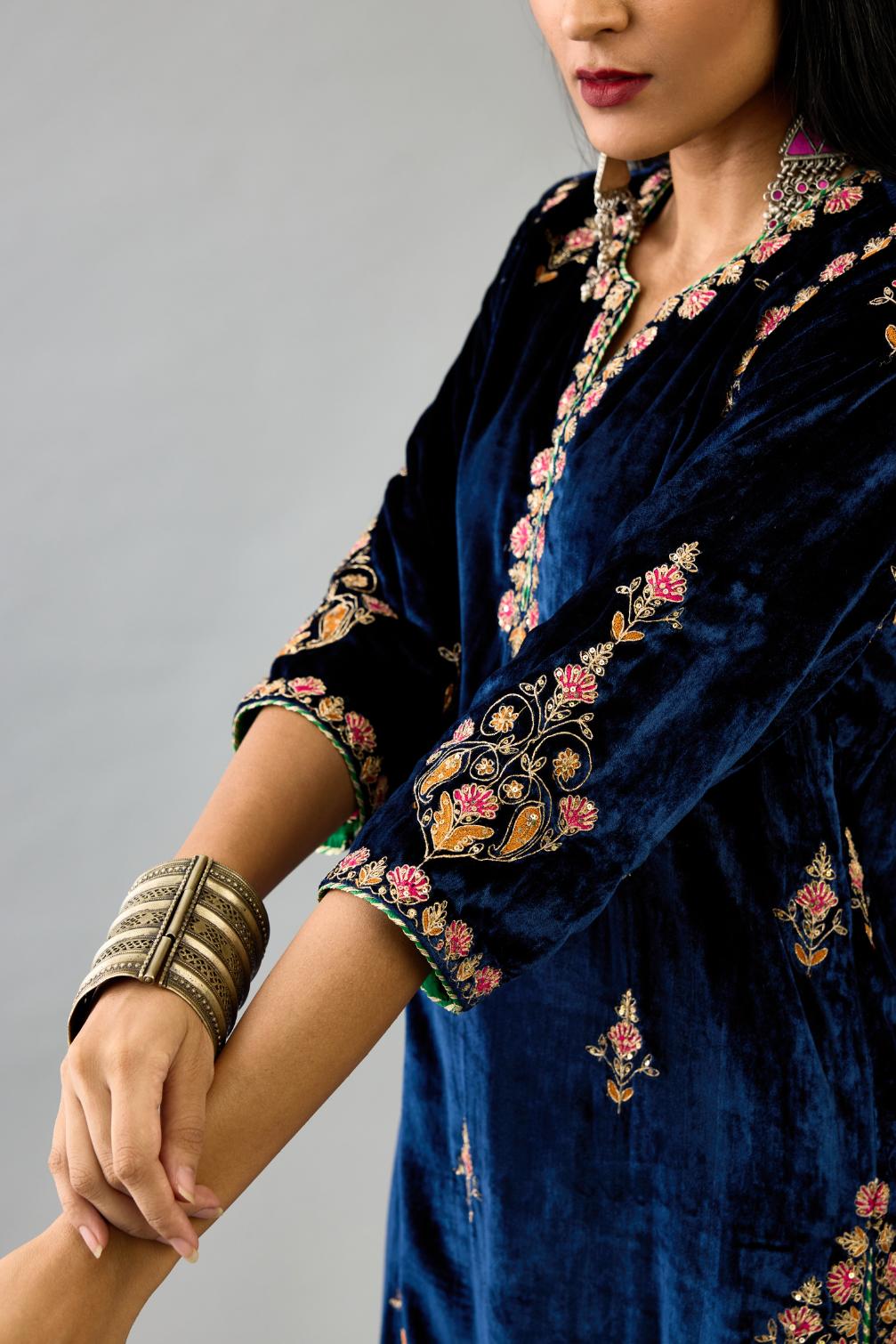Blue silk velvet straight kurta set with all-over zari, dori and contrast silk thread embroidery, highlighted with gold sequins work.