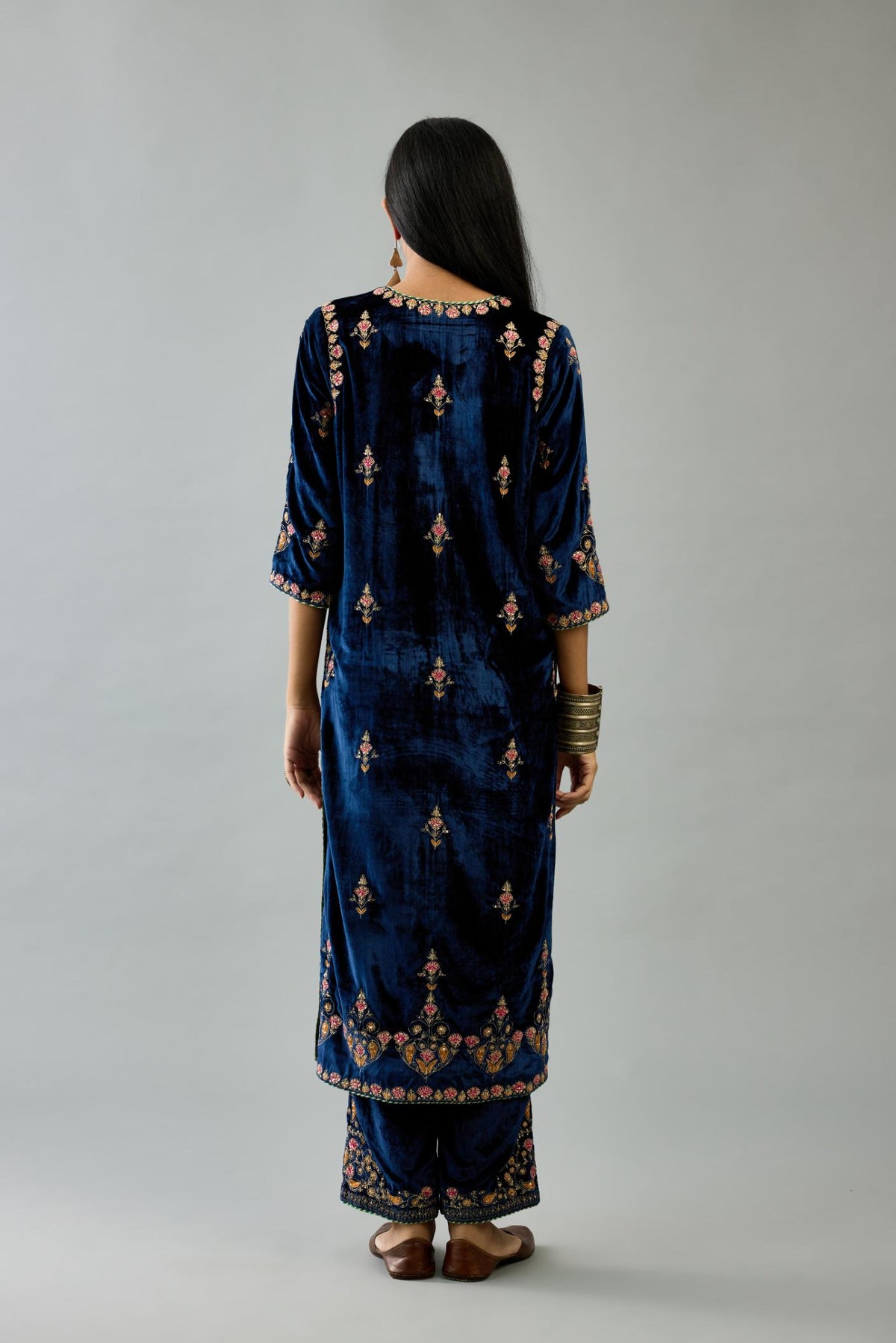 Blue silk velvet straight kurta set with all-over zari, dori and contrast silk thread embroidery, highlighted with gold sequins work.