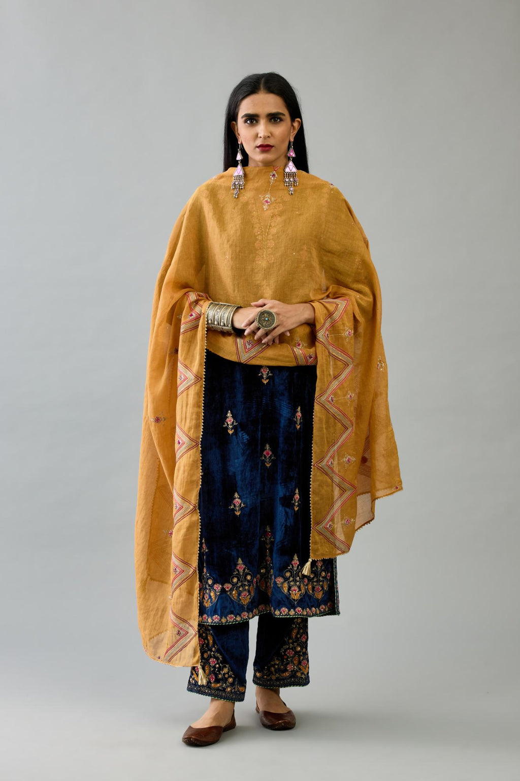 Blue silk velvet straight kurta set with all-over zari, dori and contrast silk thread embroidery, highlighted with gold sequins work.