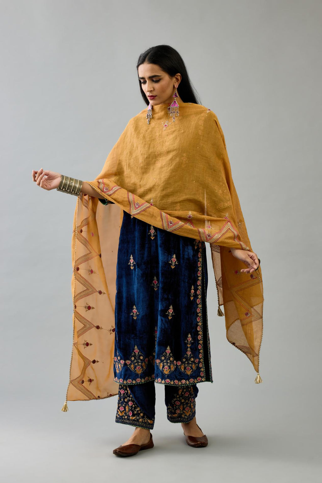 Blue silk velvet straight kurta set with all-over zari, dori and contrast silk thread embroidery, highlighted with gold sequins work.