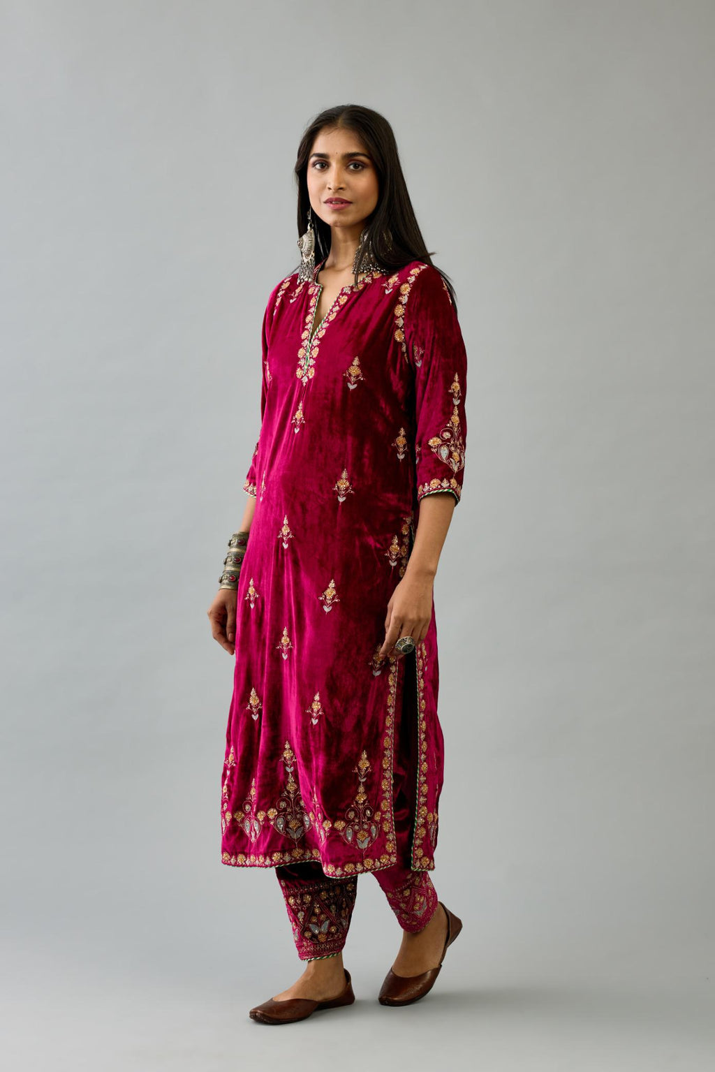 Fuchsia silk velvet straight kurta set with all-over zari, dori and contrast silk thread embroidery, highlighted with gold sequins work.