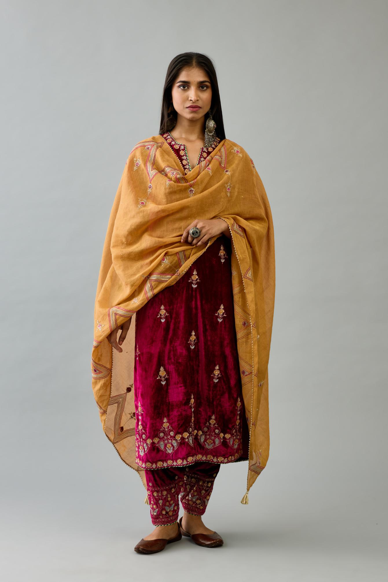 Fuchsia silk velvet straight kurta set with all-over zari, dori and contrast silk thread embroidery, highlighted with gold sequins work.