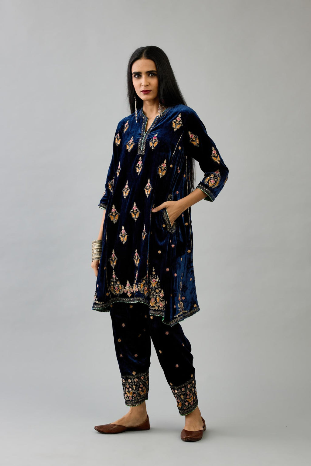 Blue silk velvet A-line short kurta set with dori and contrast silk thread embroidery, highlighted with gold sequins work.