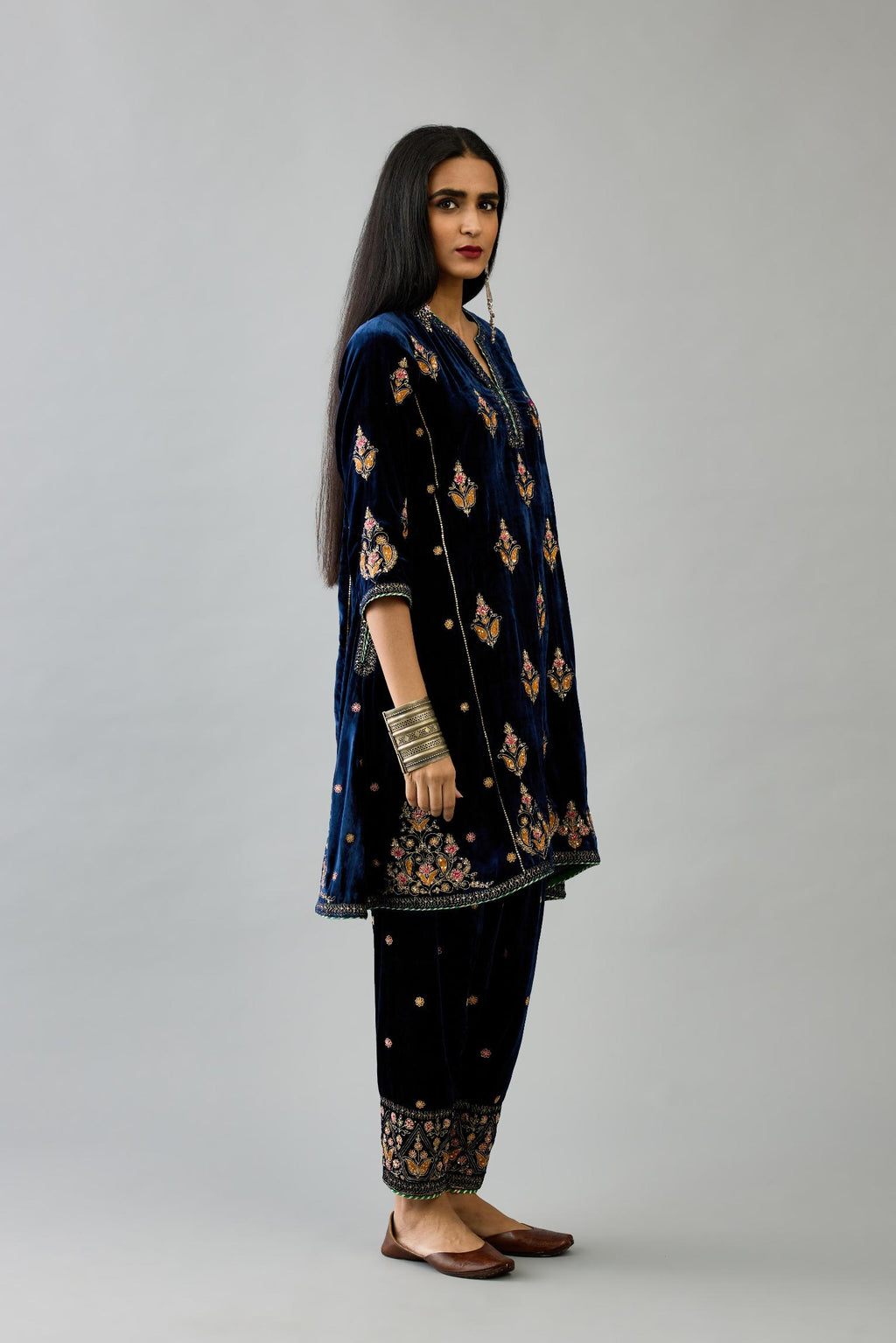 Blue silk velvet A-line short kurta set with dori and contrast silk thread embroidery, highlighted with gold sequins work.