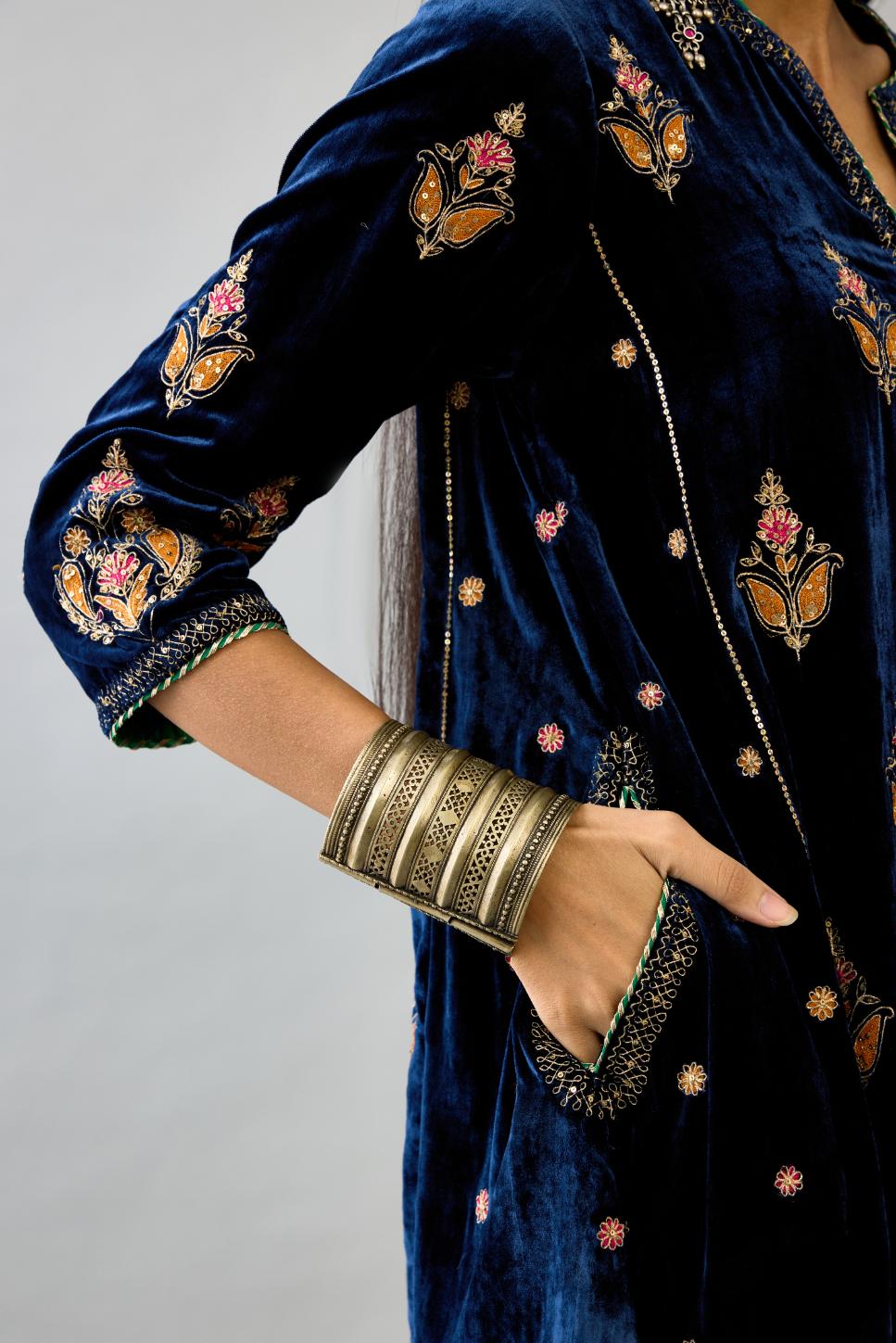Blue silk velvet A-line short kurta set with dori and contrast silk thread embroidery, highlighted with gold sequins work.