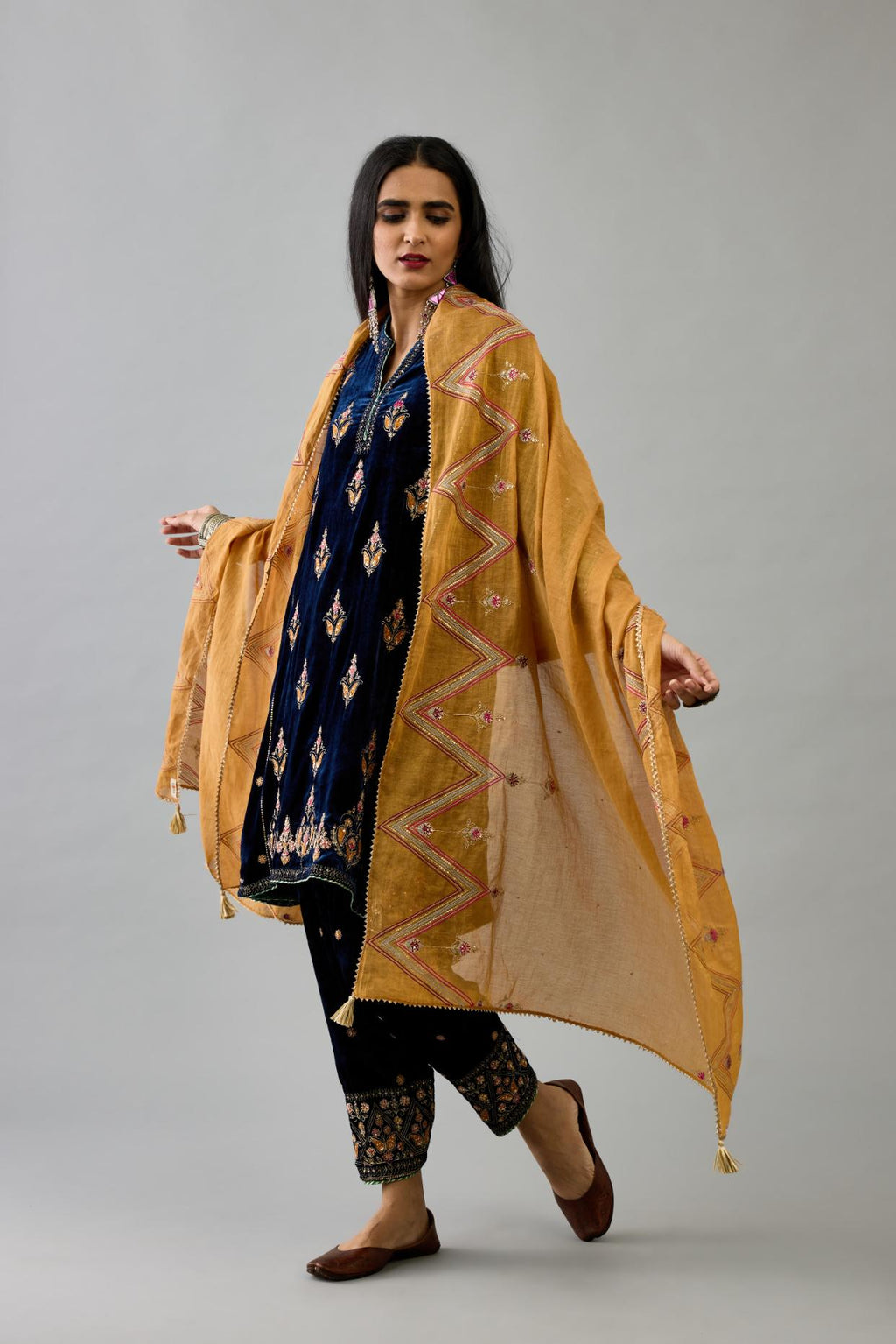 Blue silk velvet A-line short kurta set with dori and contrast silk thread embroidery, highlighted with gold sequins work.