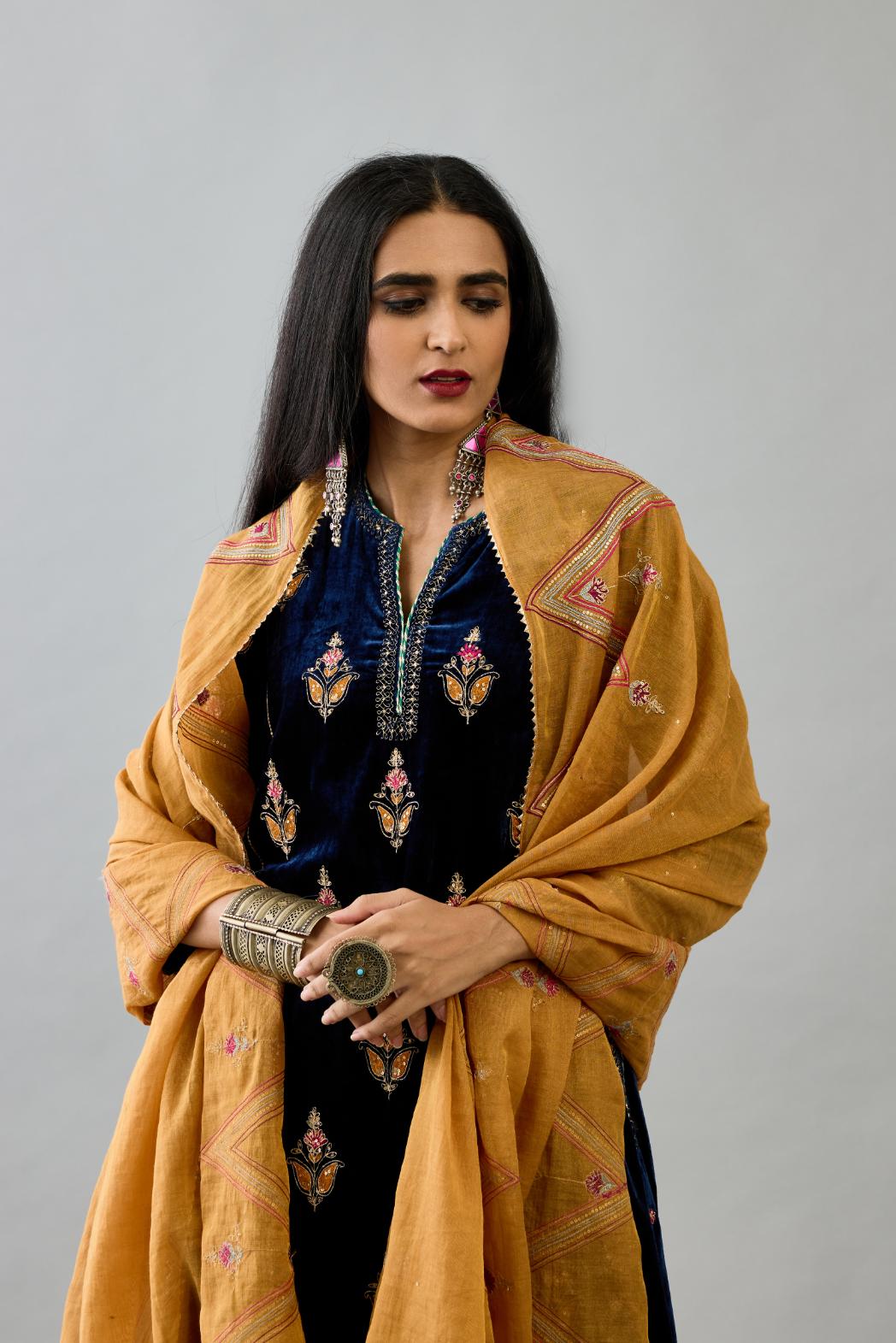 Blue silk velvet A-line short kurta set with dori and contrast silk thread embroidery, highlighted with gold sequins work.
