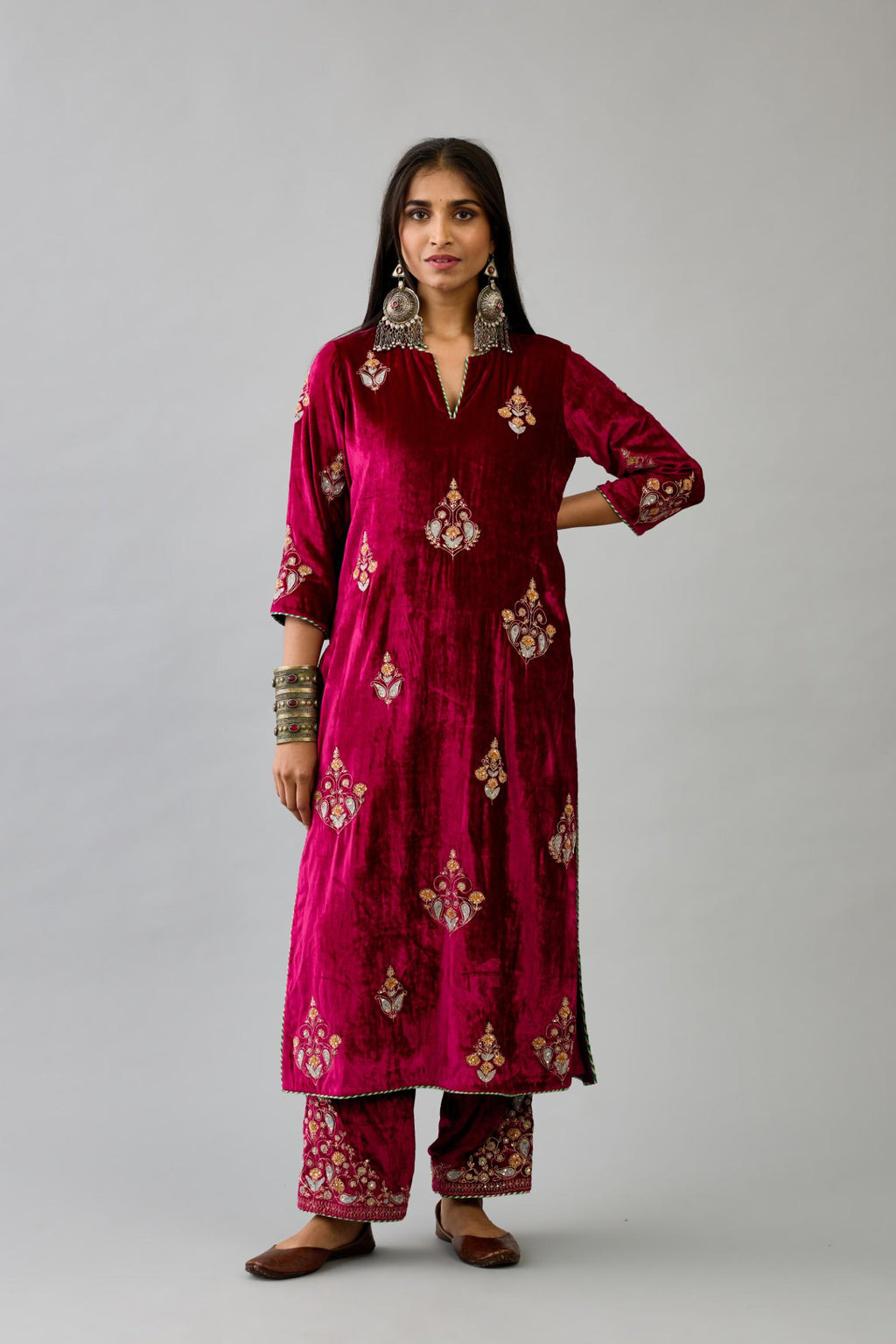 Fuchsia silk velvet straight kurta set with zari, dori and contrast silk thread embroidered bootas, highlighted with gold sequins work.