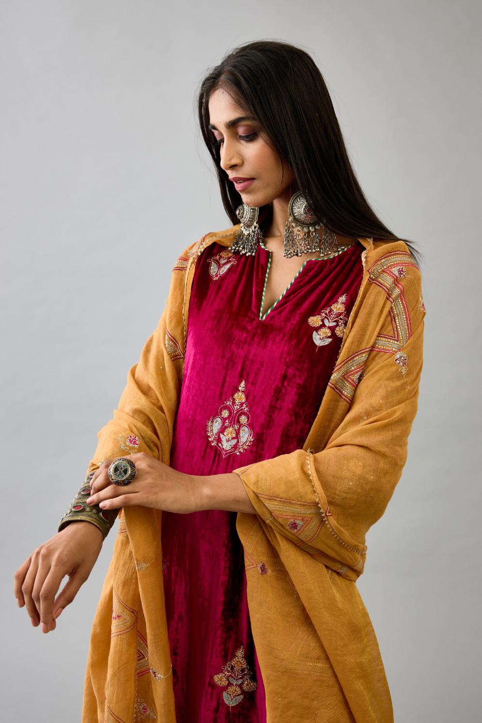 Fuchsia silk velvet straight kurta set with zari, dori and contrast silk thread embroidered bootas, highlighted with gold sequins work.