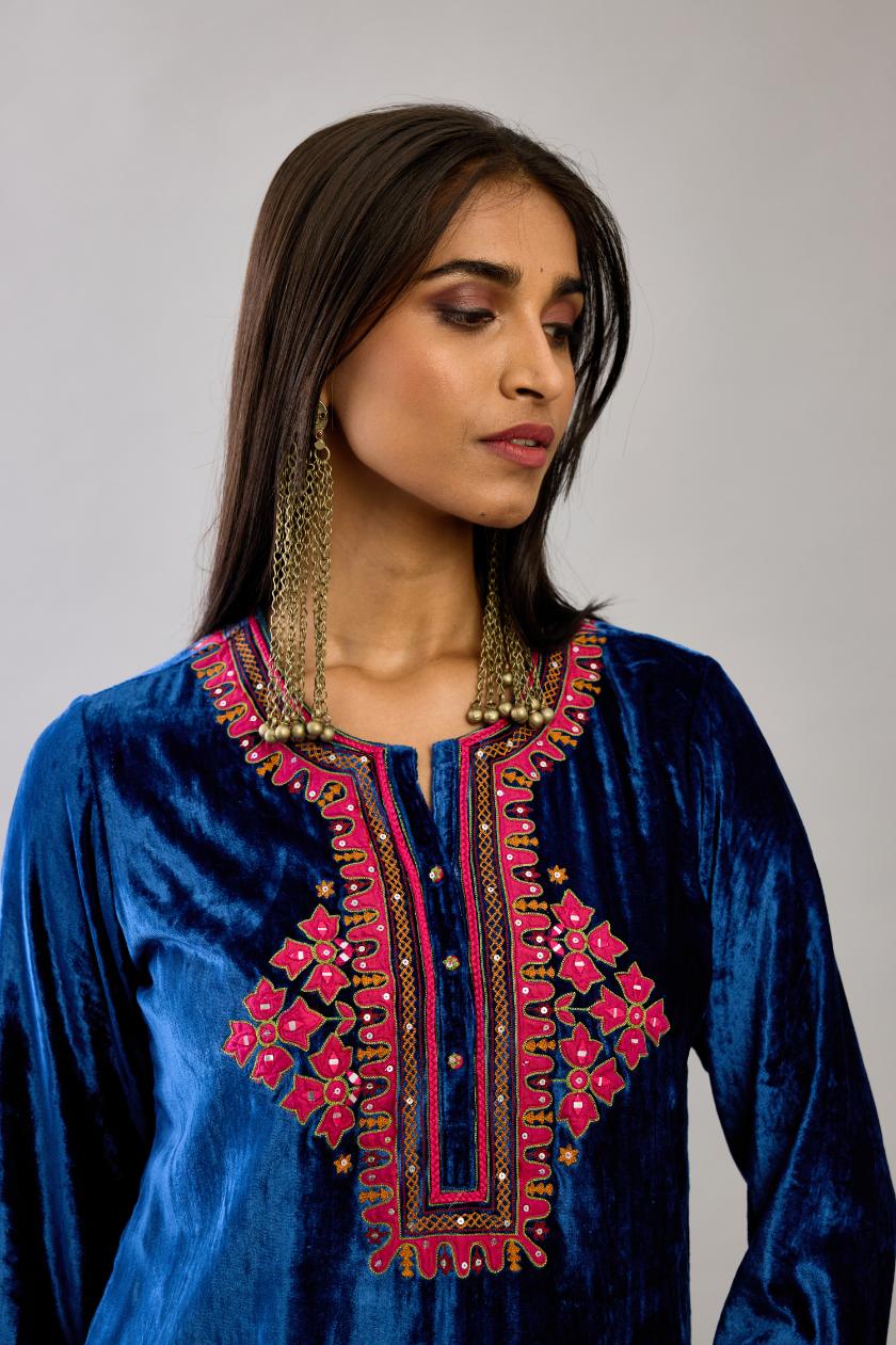 Blue silk velvet embroidered short top with 3/4th sleeves, paired with blue silk velvet straight pants with all over contrast color embroidery detailed with sequins.