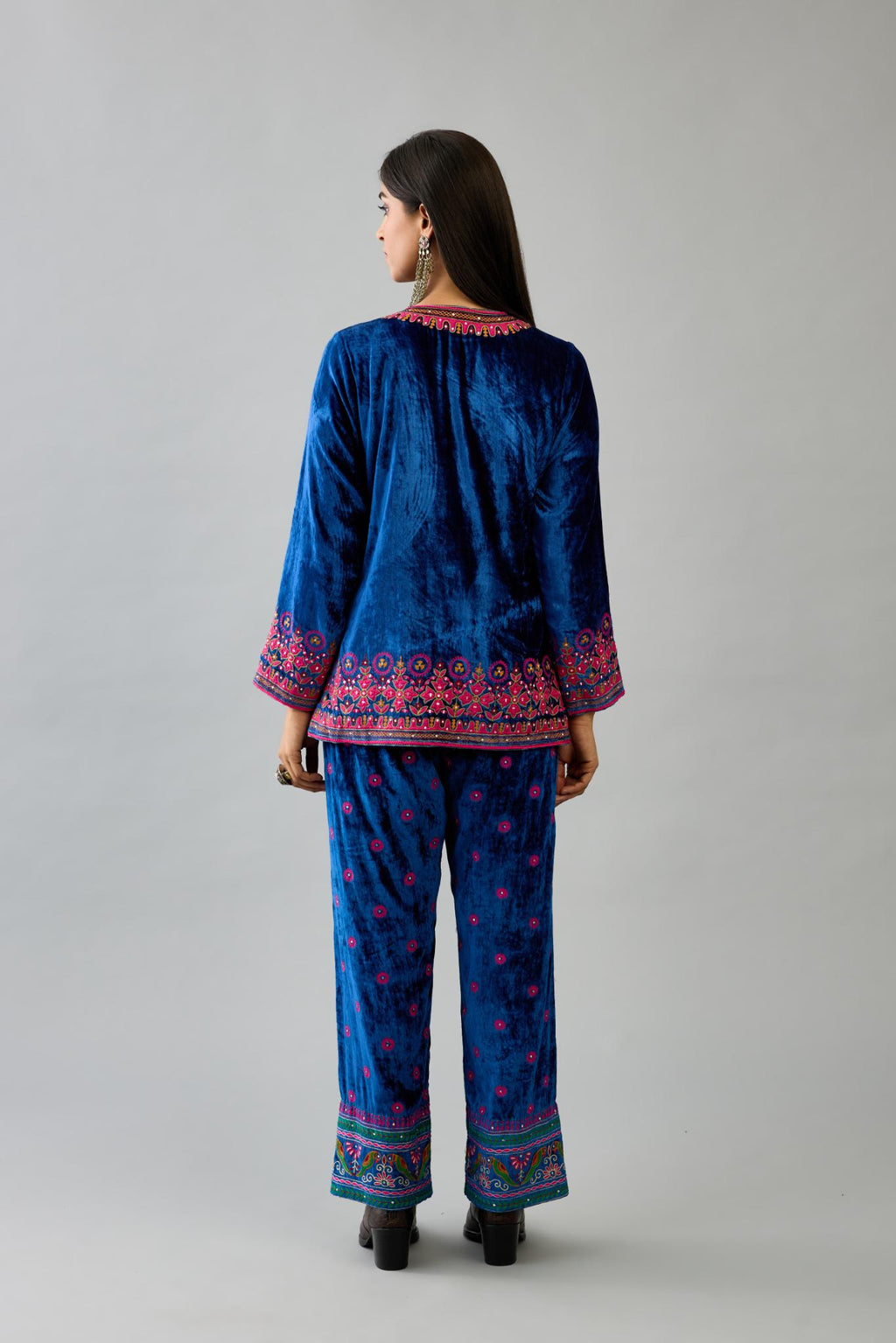 Blue silk velvet embroidered short top with 3/4th sleeves, paired with blue silk velvet straight pants with all over contrast color embroidery detailed with sequins.