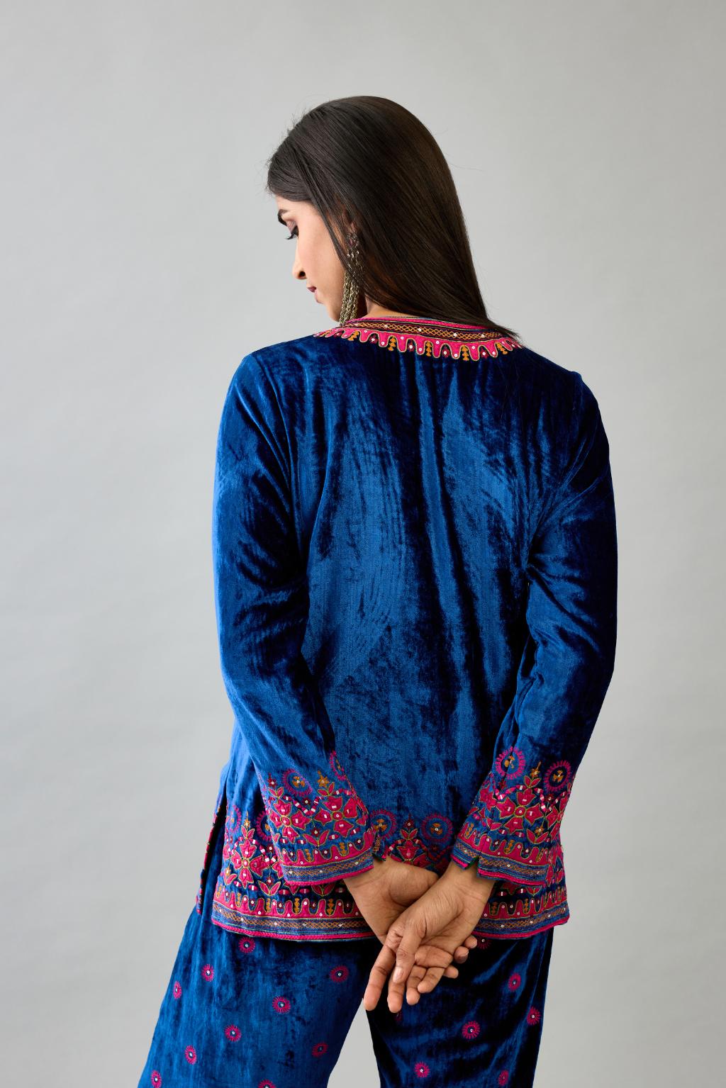 Blue silk velvet embroidered short top with 3/4th sleeves, paired with blue silk velvet straight pants with all over contrast color embroidery detailed with sequins.