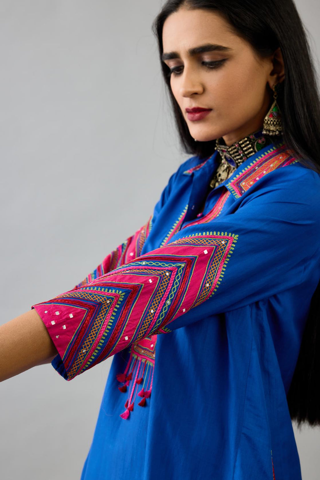 Blue Silk A-line kurta with collar, detailed with patchwork, silk thread embroidery, mirrors, sequins and tassels.