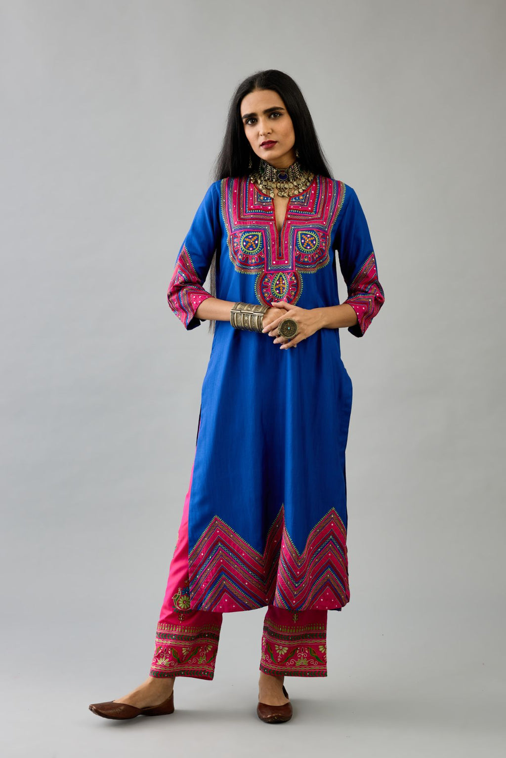 Blue silk straight kurta set with patchwork and thread embroidery highlighted with mirrors, sequins, tassels and braids.