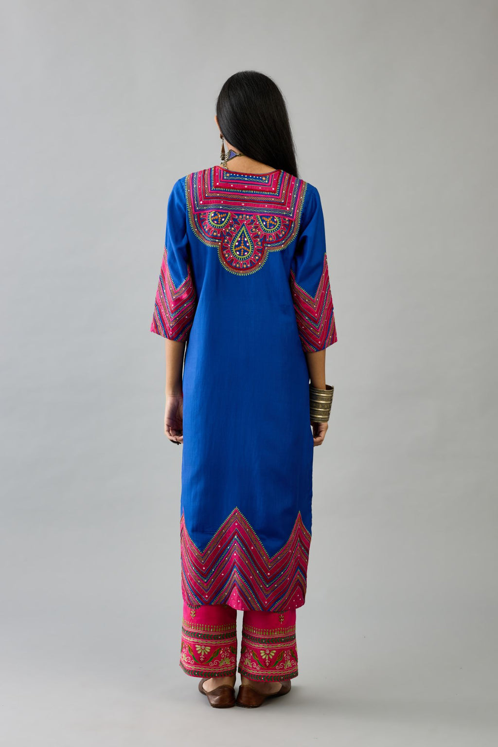 Blue silk straight kurta set with patchwork and thread embroidery highlighted with mirrors, sequins, tassels and braids.